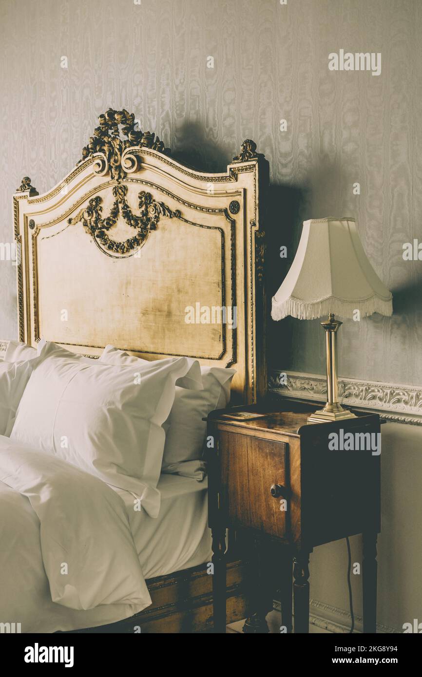 Klassisches englisches Bett mit goldenem Kopfteil. Stockfoto