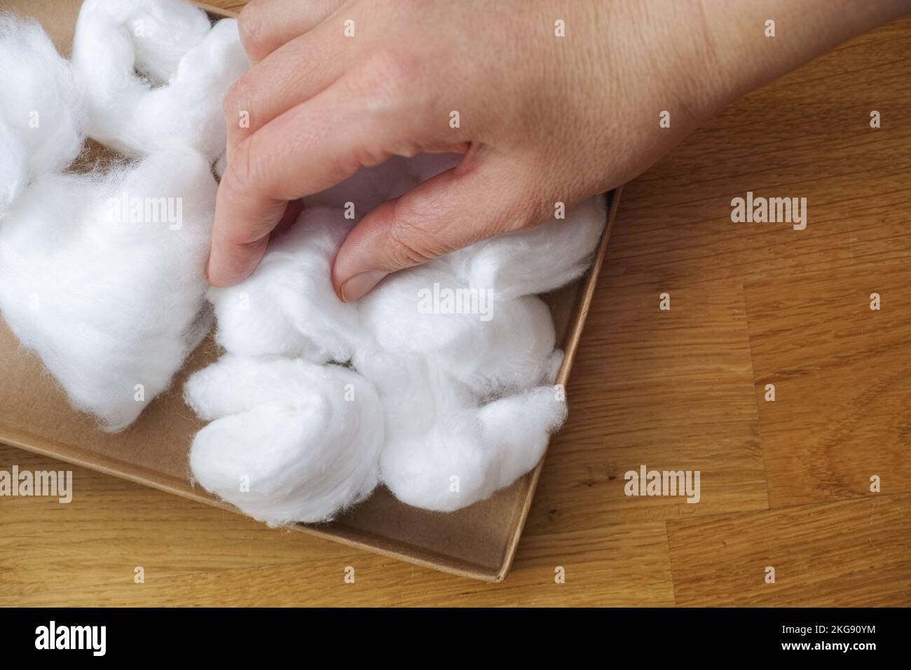Eine Frau, die einen Wattebausch aus einem Karton nimmt. Nahaufnahme. Stockfoto