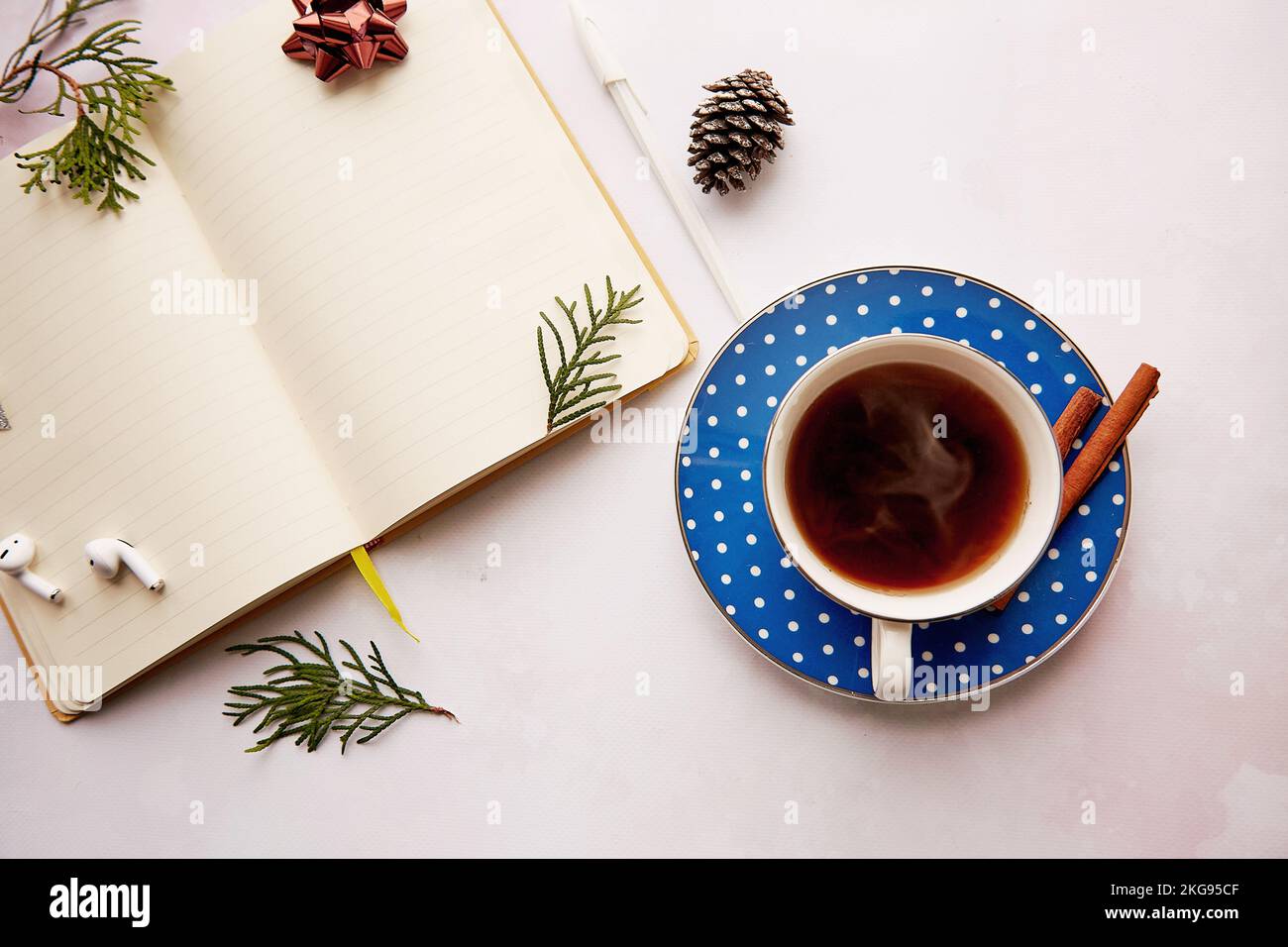 Saisonaler Notizblock mit Mockup-Notizblock für Neujahr mit ästhetischer Kaffeetasse und Donut. Schnurlose Ohrhörer. Auflösung des neuen Jahres, Planung, Neubeginn und Liste der Ziele Stockfoto