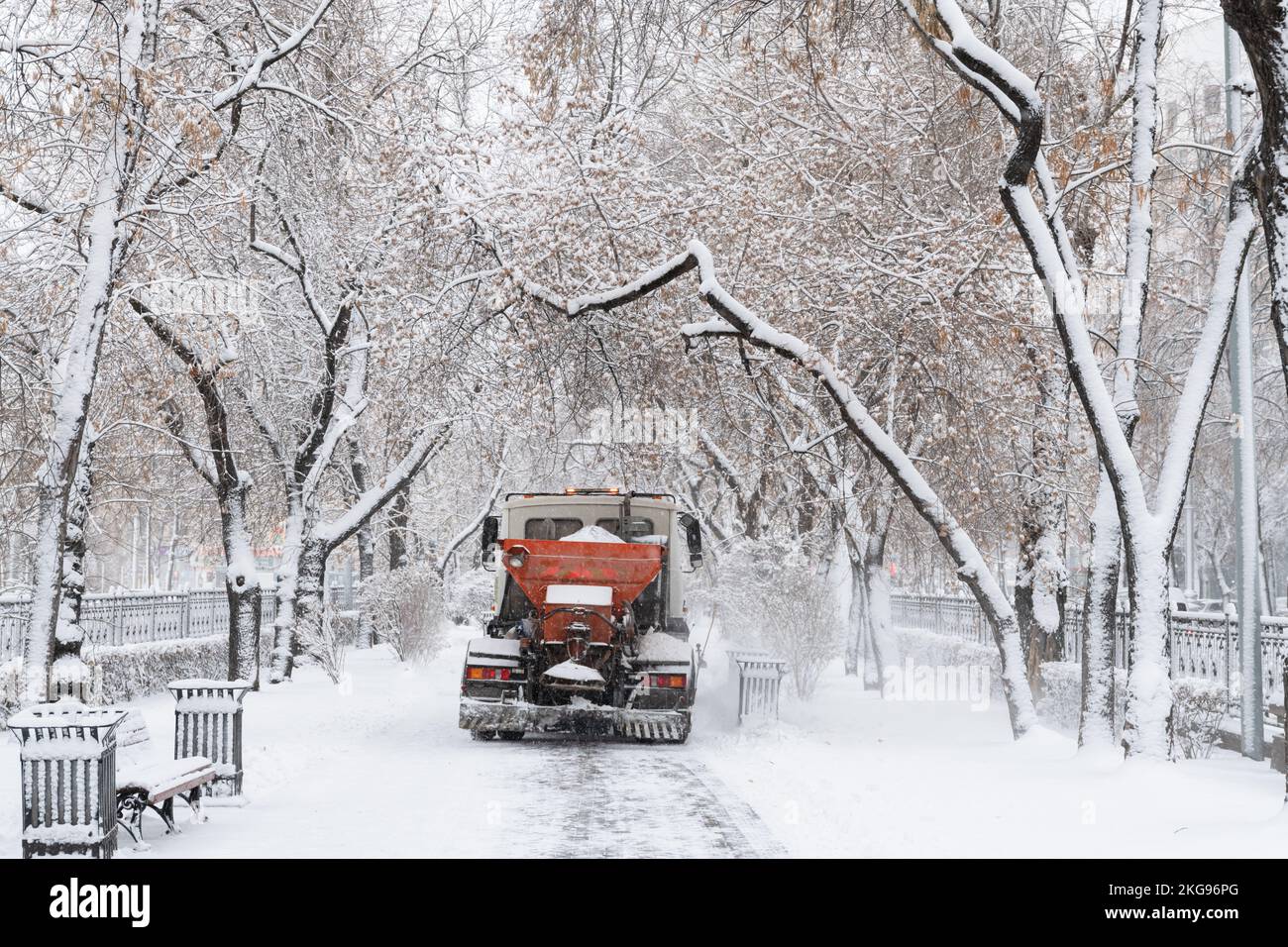 Roter Schneepflug räumt nach Schneefall Schnee in der Stadt Stockfoto