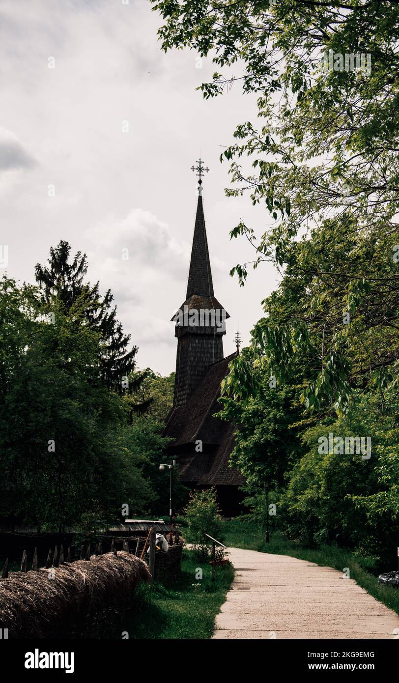 Eine vertikale Aufnahme einer katholischen Kirche mit einem Kreuz auf dem Dach im Dimitrie Gusti Museum Stockfoto