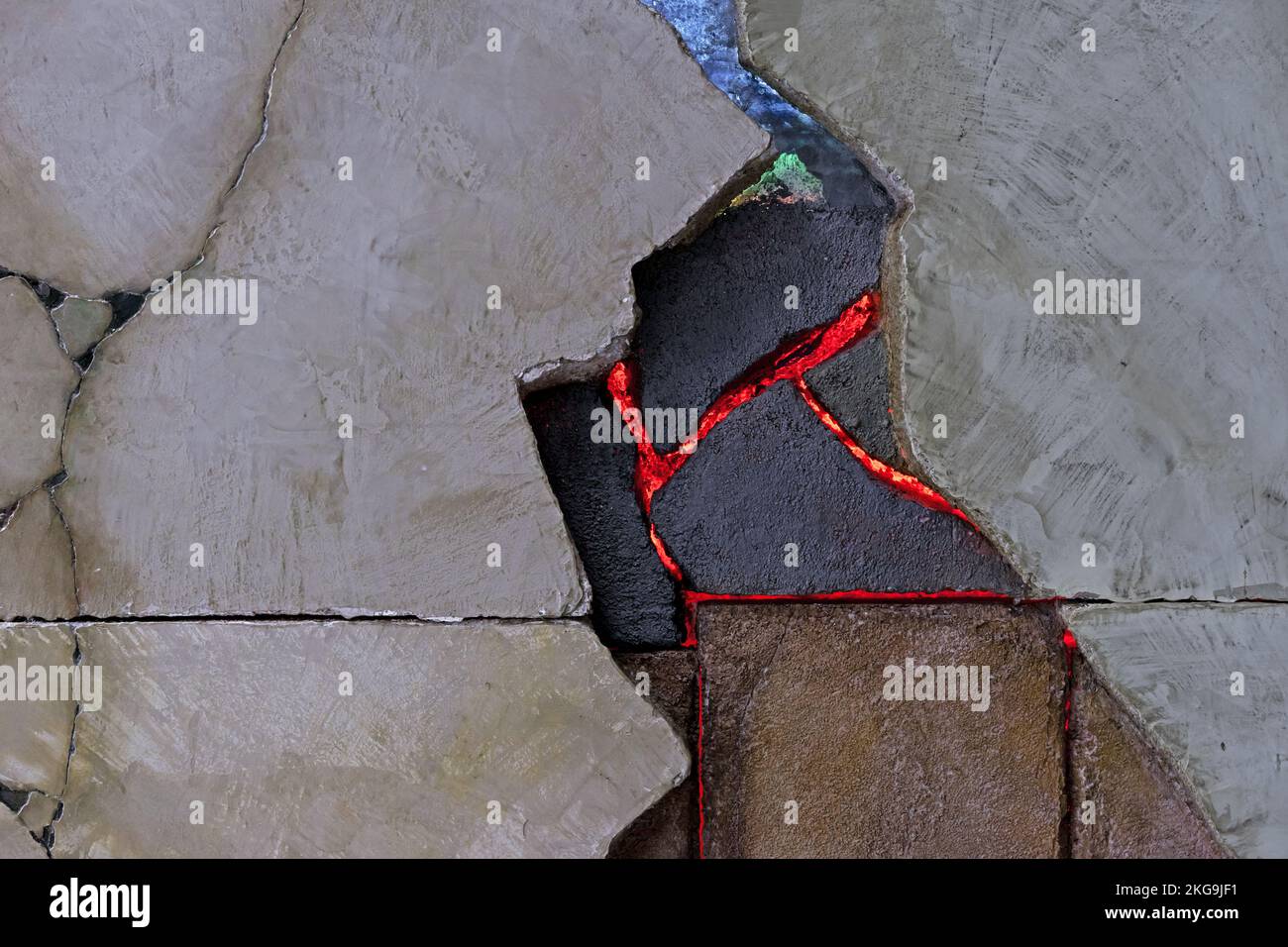 Wandplatte aus rauem Stein mit Rissen, Brüchen und LED-Innenbeleuchtung. Stockfoto