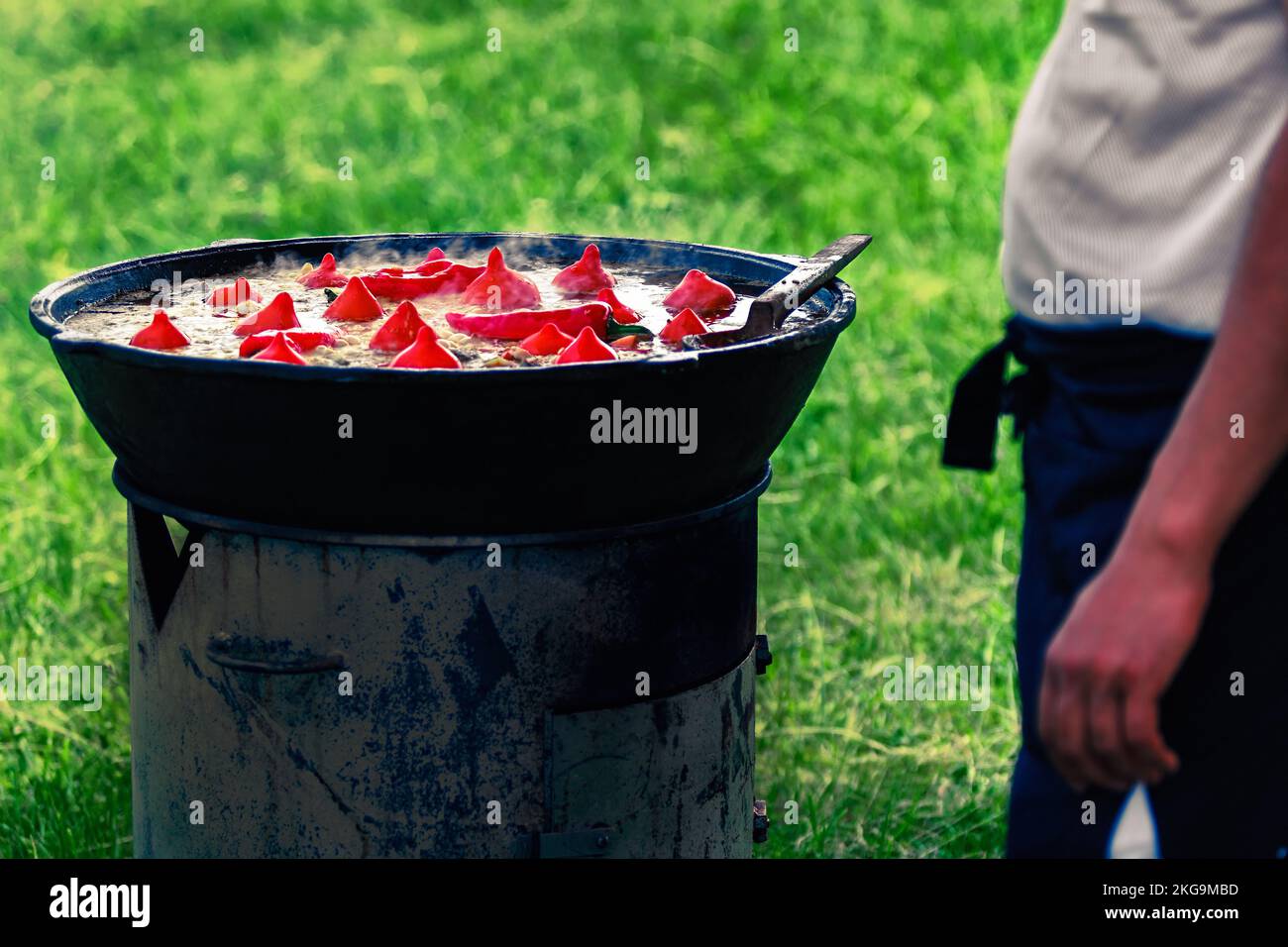 Der Koch bereitet Usbek Pilaf mit Paprika im Freien zu Stockfoto