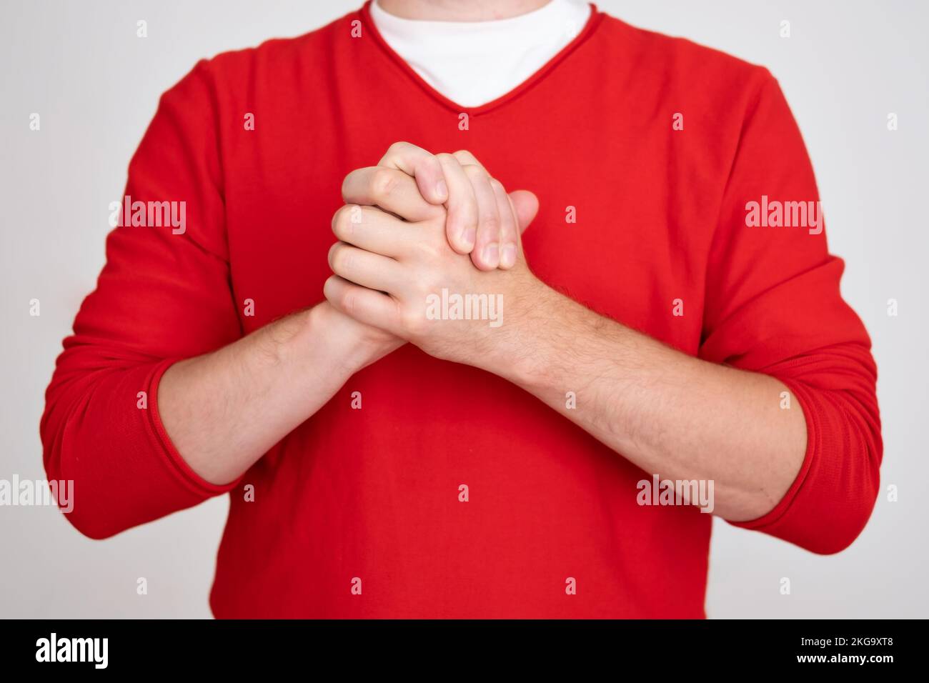 Ein weißer junger Mann schüttelt sich die Hände. Sei in Frieden, ich unterstütze dich Stockfoto