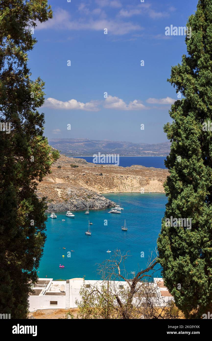 Panoramablick auf den farbenfrohen Hafen im Dorf Lindos, Rhodos. Luftaufnahme der schönen Landschaft, Meer mit Segelbooten und Küste der Insel Rhodos in der Ägäis. Hochwertige Fotos Stockfoto