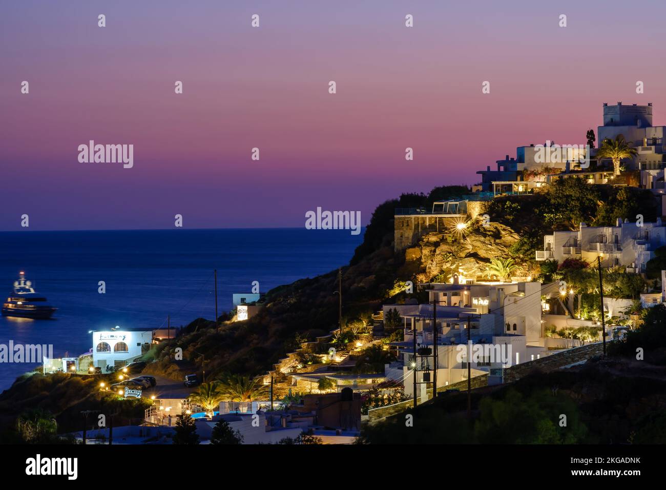 IOS, Griechenland - 13. September 2022 : atemberaubender violetter Sonnenuntergang und Blick auf die beleuchteten, malerischen Hotels und Restaurants in iOS Greece Stockfoto