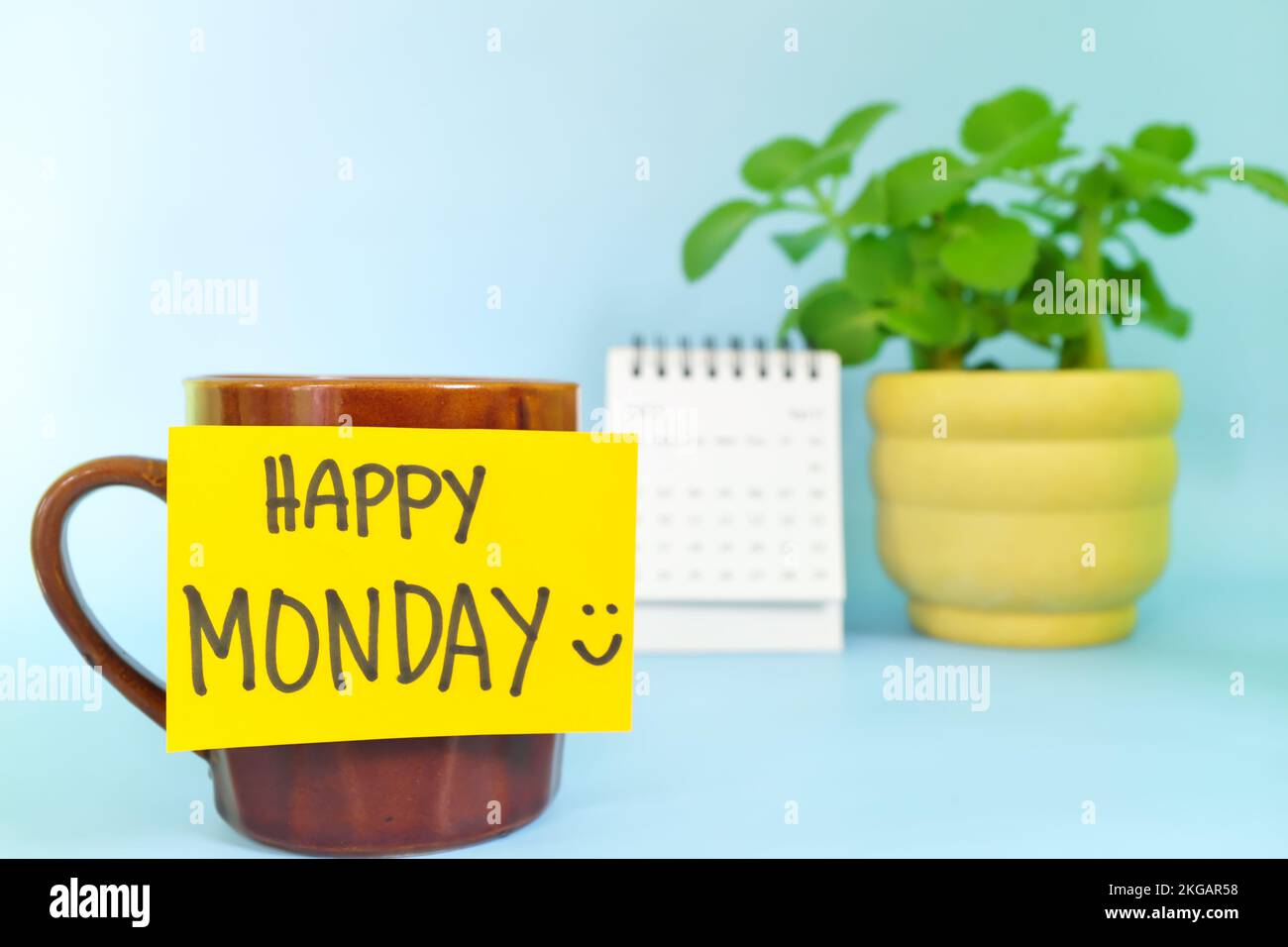 Willkommen, hallo und Happy Monday Concept. Selektiver Fokus der Kaffeetasse mit hellgelbem Zettel und schriftlicher Nachricht. Stockfoto