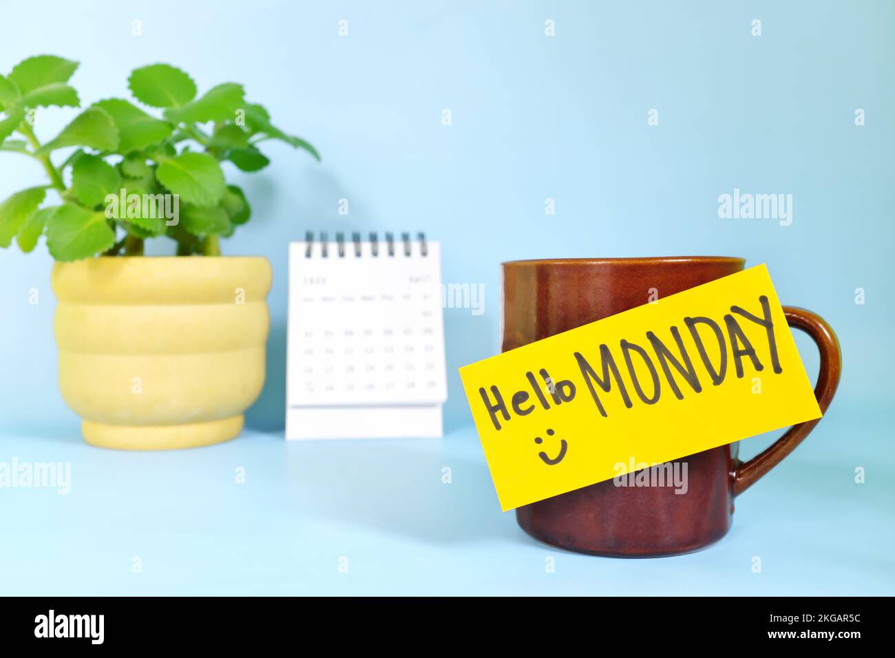 Willkommen, hallo und Happy Monday Concept. Selektiver Fokus der Kaffeetasse mit hellgelbem Zettel und schriftlicher Nachricht. Stockfoto