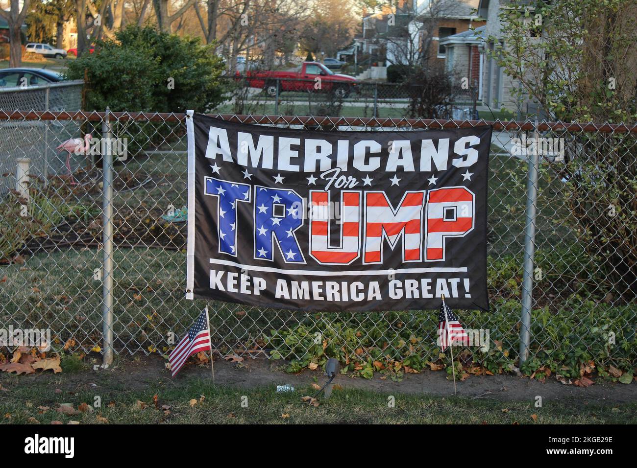 Amerikaner für Trump halten das „America Great“-Banner mit Flaggen in des Plaines, Illinois, auf einem Zaun Stockfoto