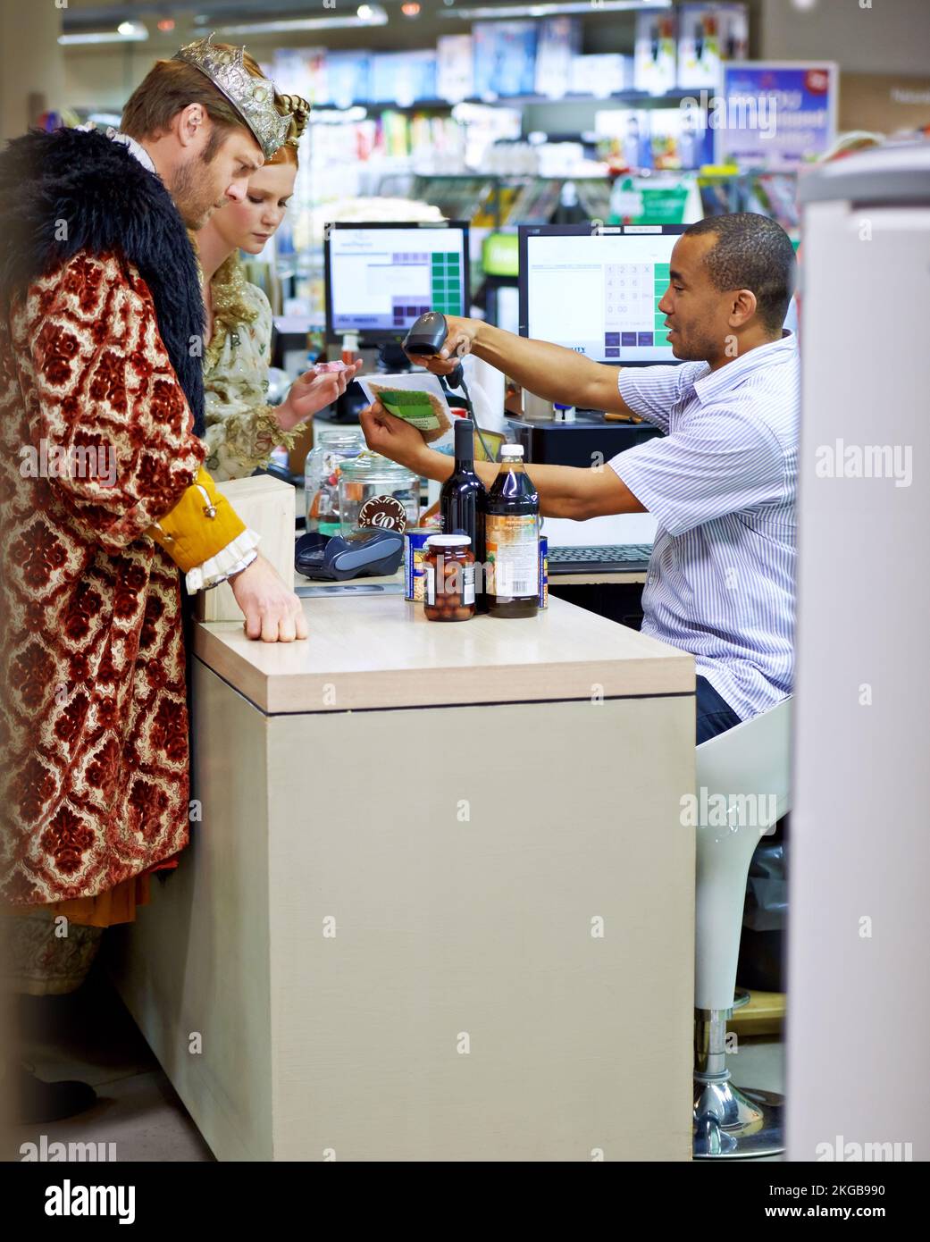 Wir haben einen Coupon dafür... Ein König und eine Königin, die Lebensmittel einkaufen und an der Kasse bezahlen. Stockfoto