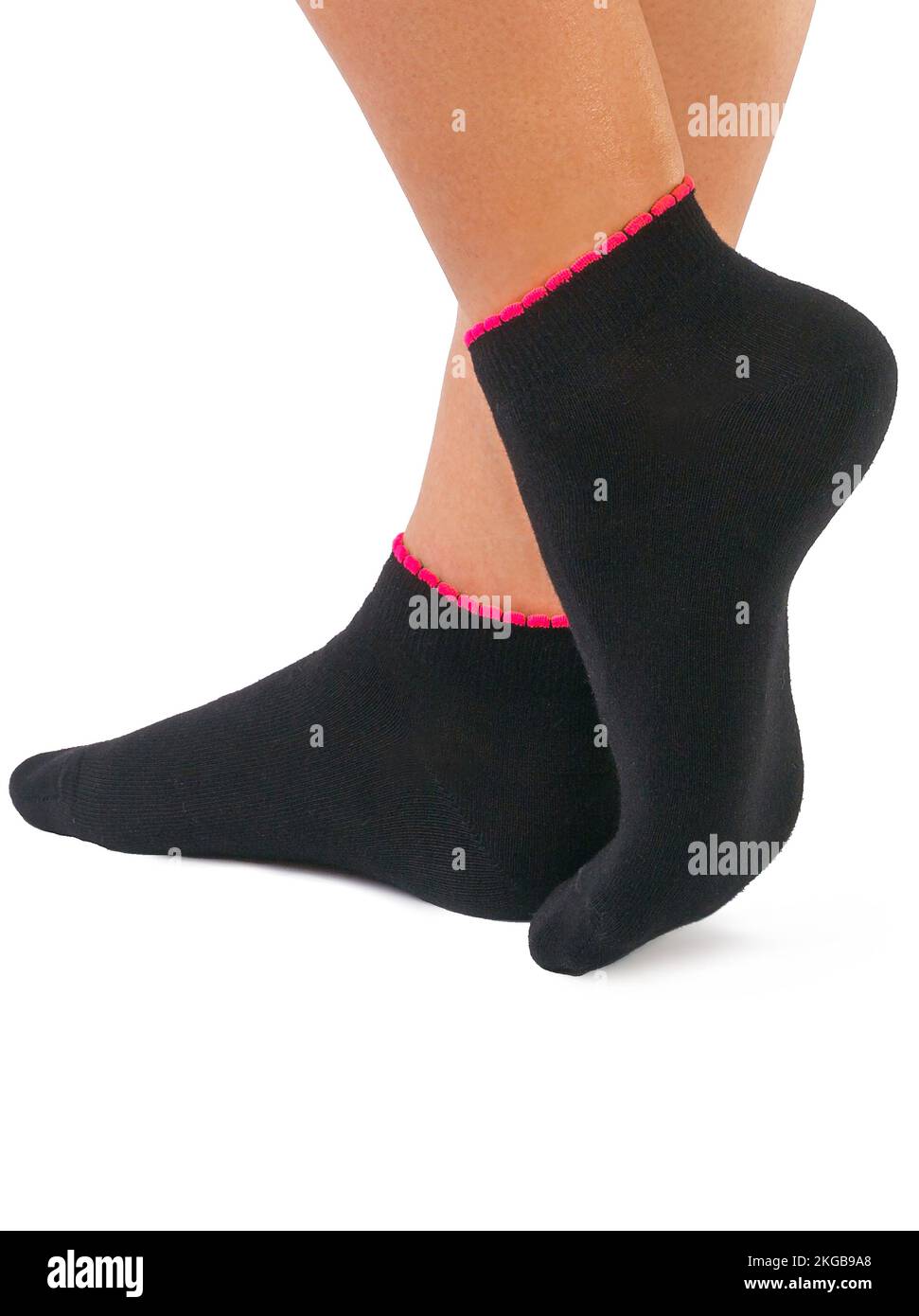 Seitenansicht eines wunderschönen Frauenfußes, gekleidet in neuen, schönen und weichen schwarzen Socken aus natürlichem Baumwollgewebe mit roten Kanten isoliert auf weißem Hintergrund. W Stockfoto