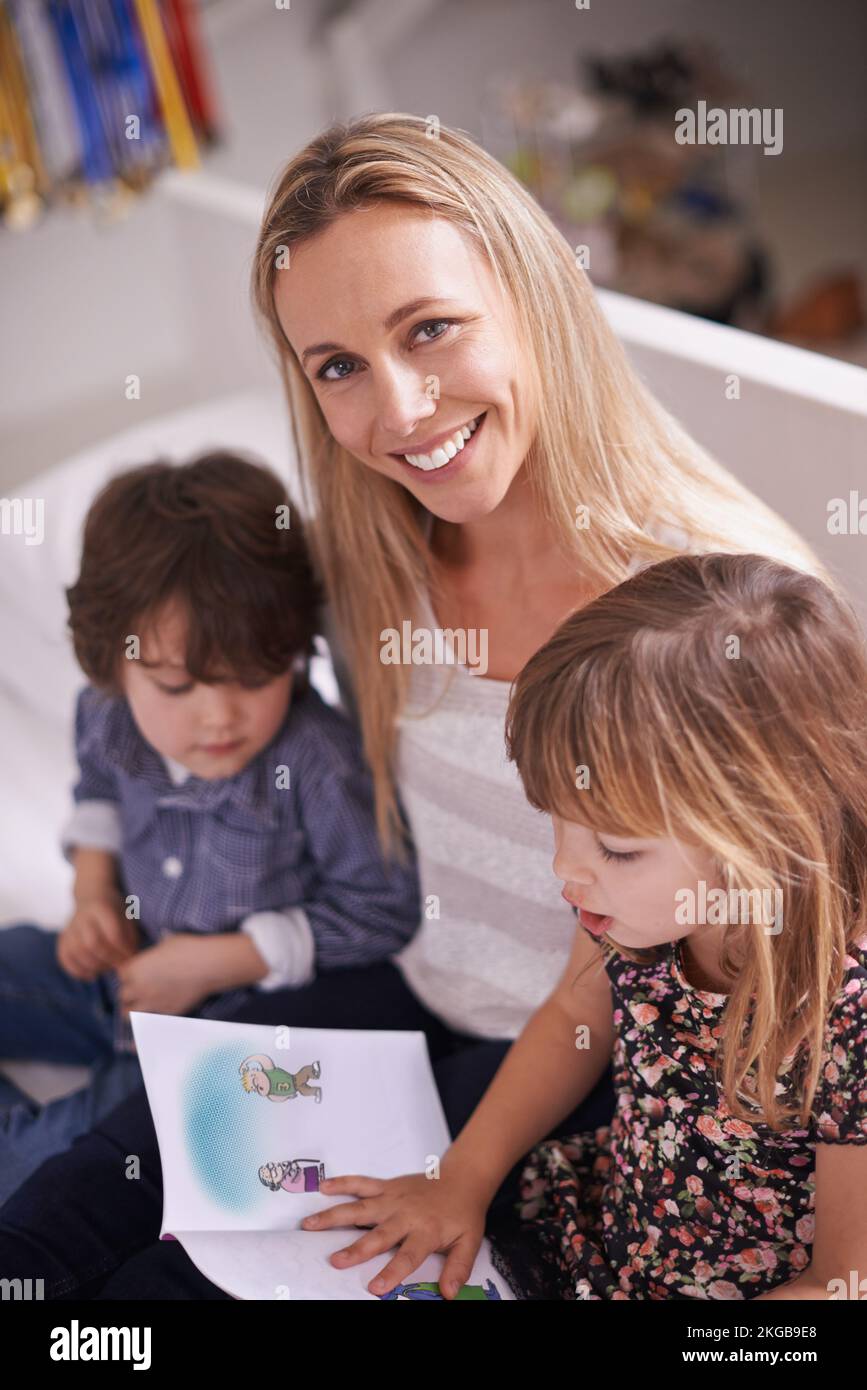 Das sind kleine Bücherwürmer. Eine Mutter, die mit ihren Kindern zu Hause liest. Stockfoto