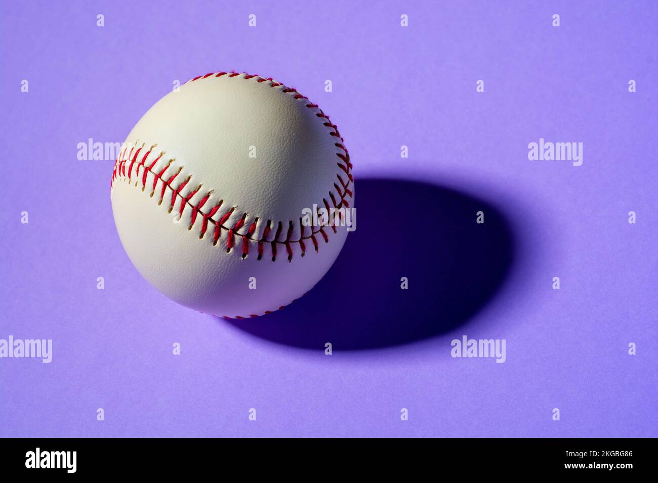 Baseballball auf violettem Hintergrund Nahaufnahme mit Schatten Stockfoto