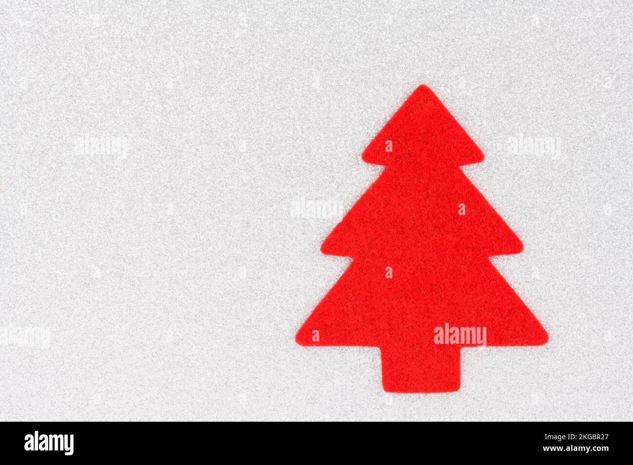 Weihnachtlicher Hintergrund mit roter Form eines Weihnachtsbaums isoliert auf silbernem Hintergrund. Mit Kopierbereich. Stockfoto