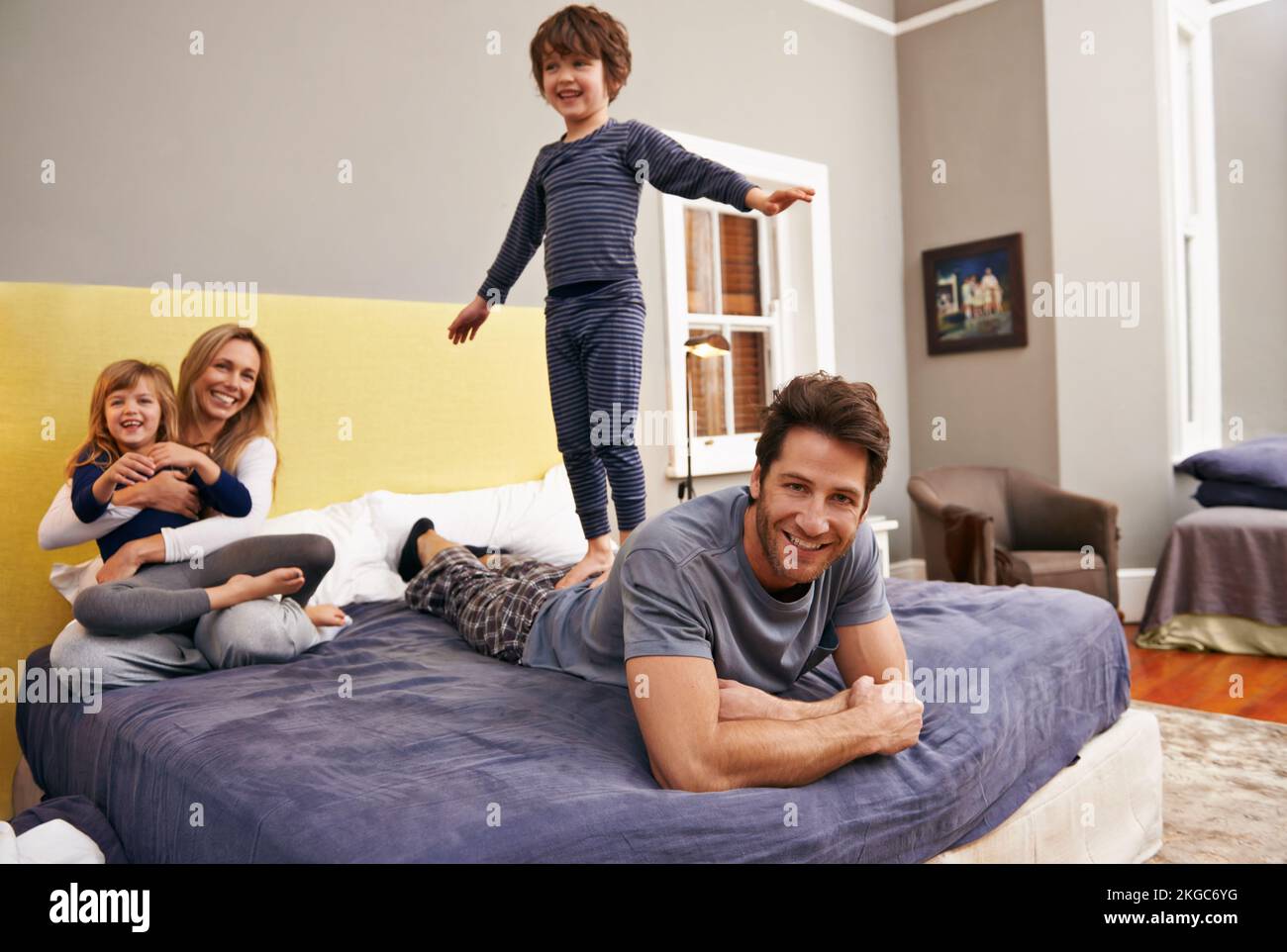 Zeit für eine Familienbande. Porträt einer jungen Familie, die sich zu Hause im Schlafzimmer anfreundet. Stockfoto