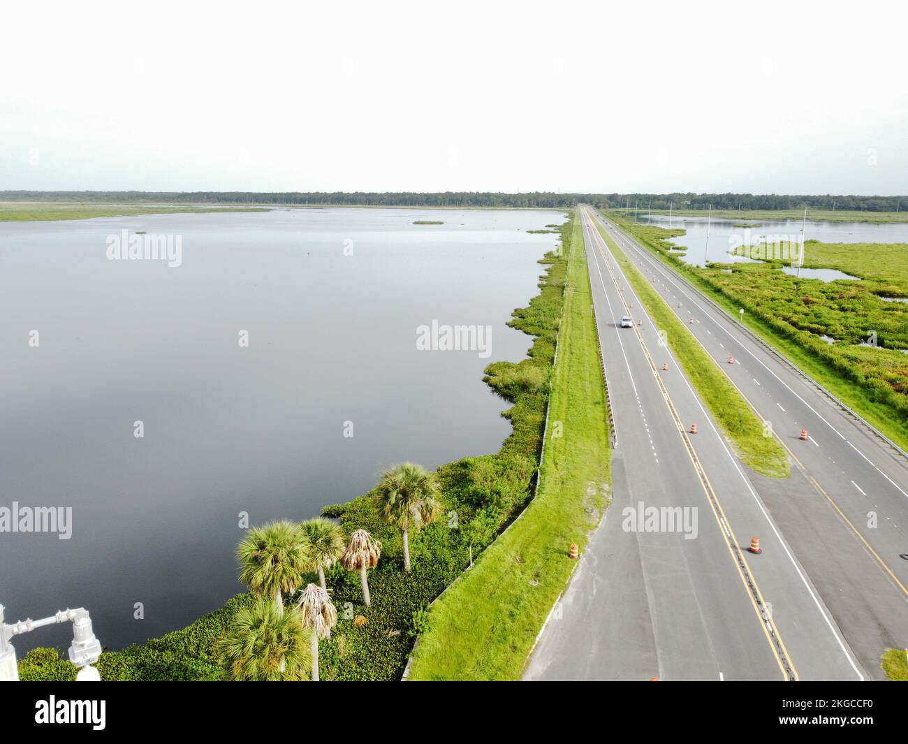 Eine Landschaft einer zweispurigen Straße über dem Wasser, umgeben von Grün Stockfoto