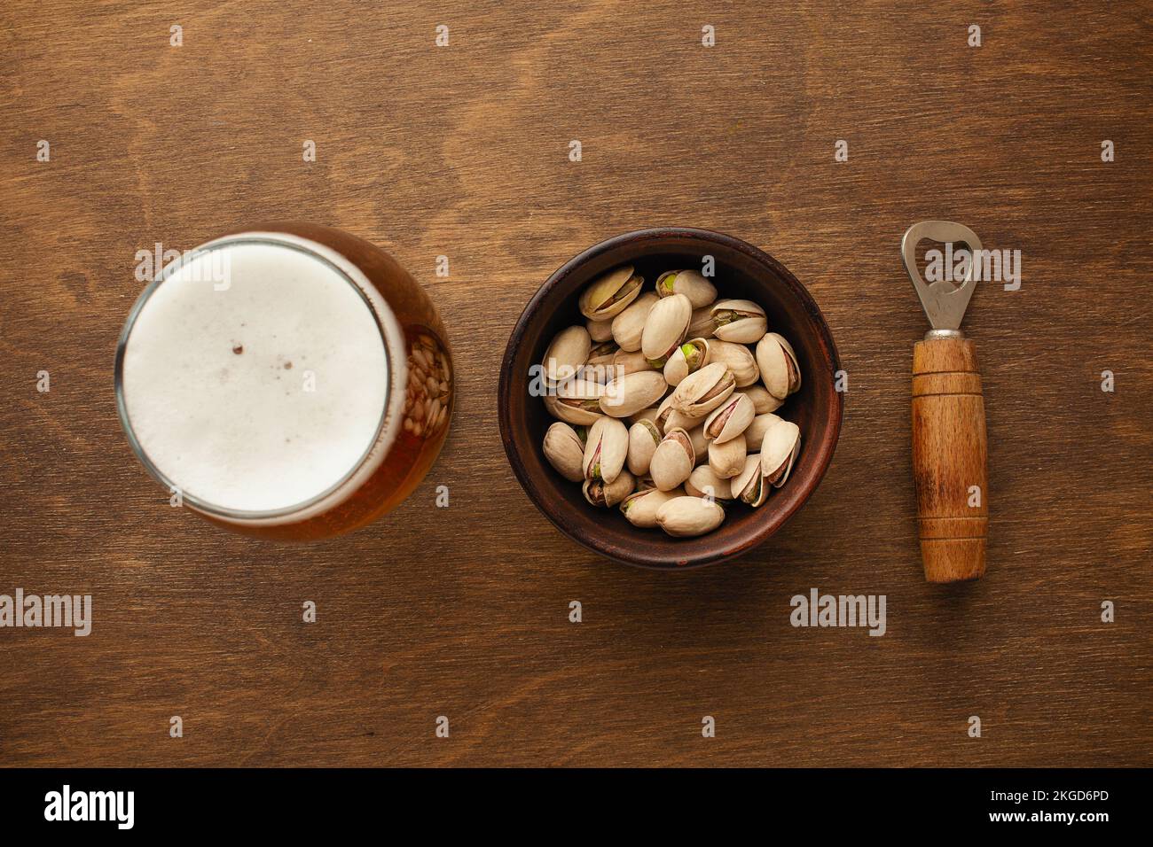 Eine Flasche Bier auf einem Teller mit gesalzenen Auberginen Brezeln, Pistaziennüssen und Chips auf einem schwarzen, zerkratzten Kreidetafel. Draufsicht. Hochwertiges Foto Stockfoto