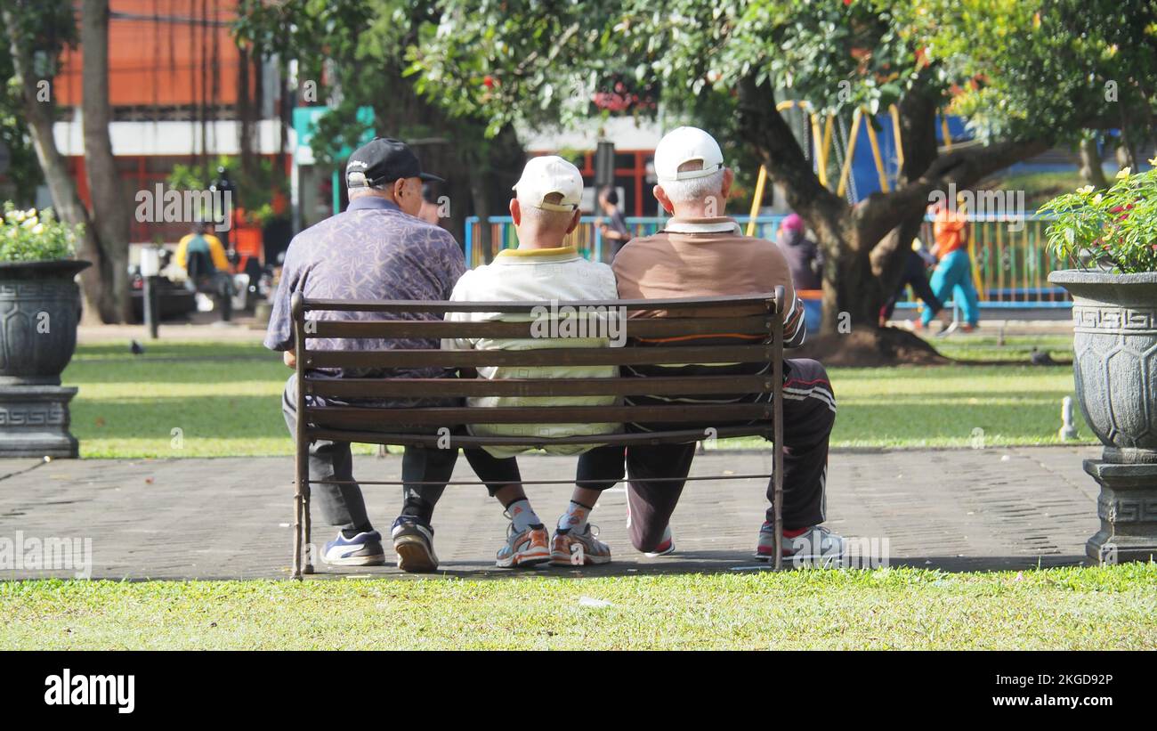 Freundschaft bis ins hohe Alter. Drei Erwachsene sitzen in den Stühlen der Stadt Alun-alun Malang in Ostjava. MALANG, INDONESIEN. 08. MÄRZ 2018. Stockfoto
