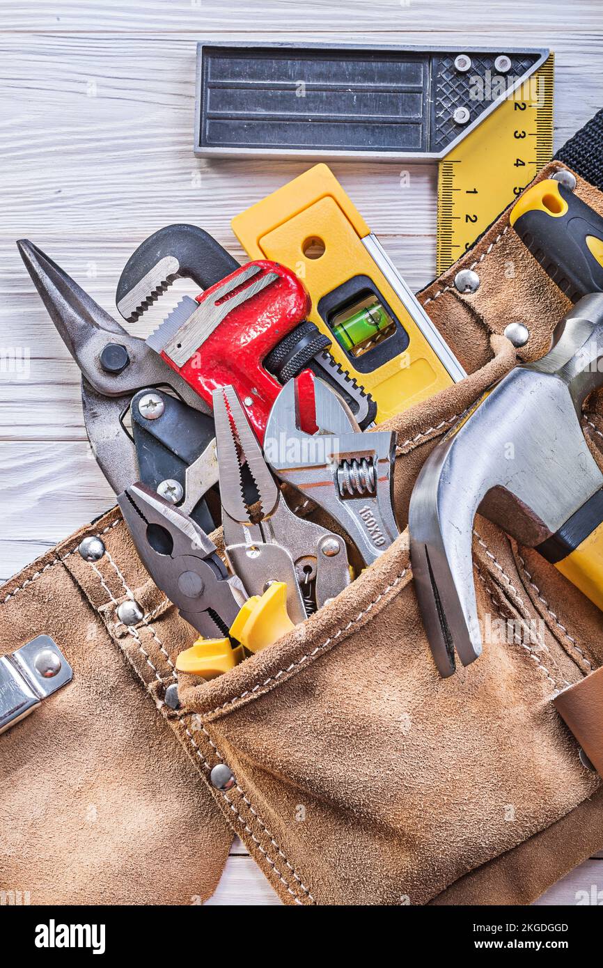 Baugeräte im Werkzeuggürtel auf Holzbrettbaukonzept. Stockfoto