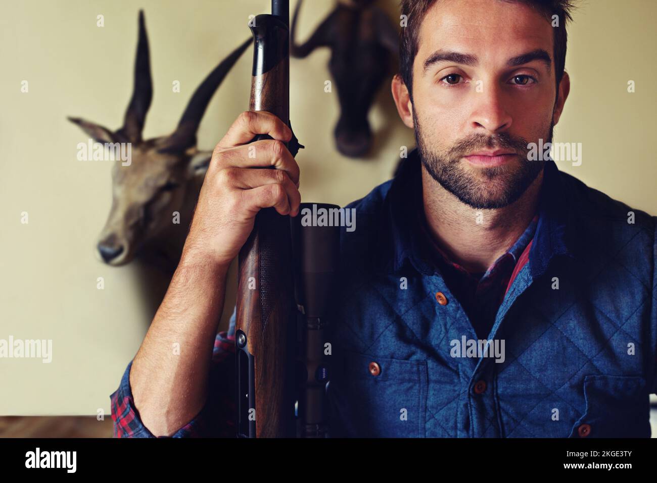 Das Leben eines Jägers. Porträt eines Jägers, der vor seinen Trophäen steht. Stockfoto