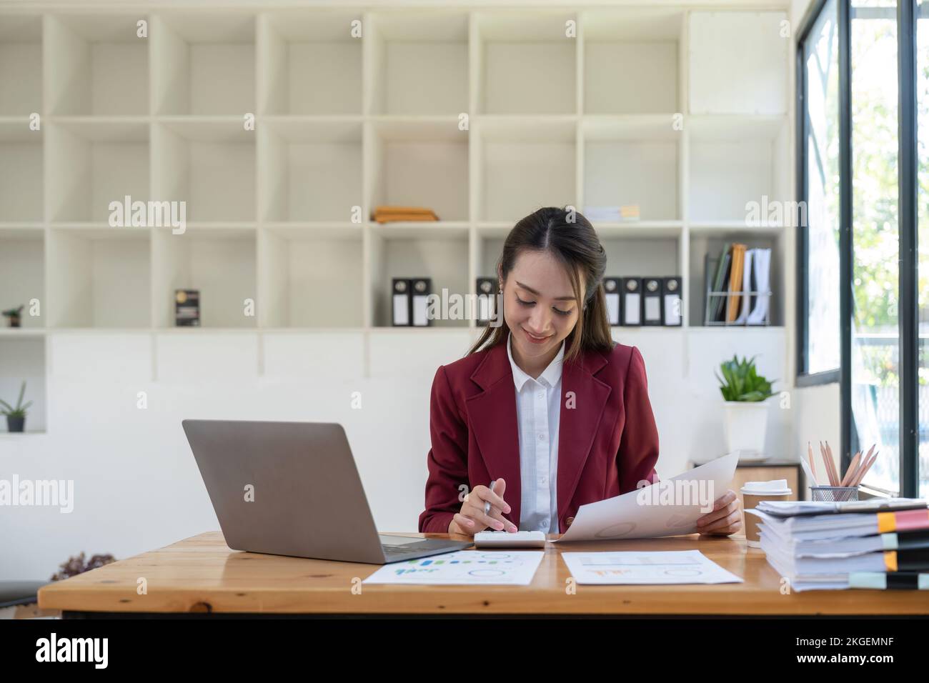 Buchhalterin, die die Finanzen übernimmt und am Schreibtisch die Kosten im Büro berechnet. Stockfoto