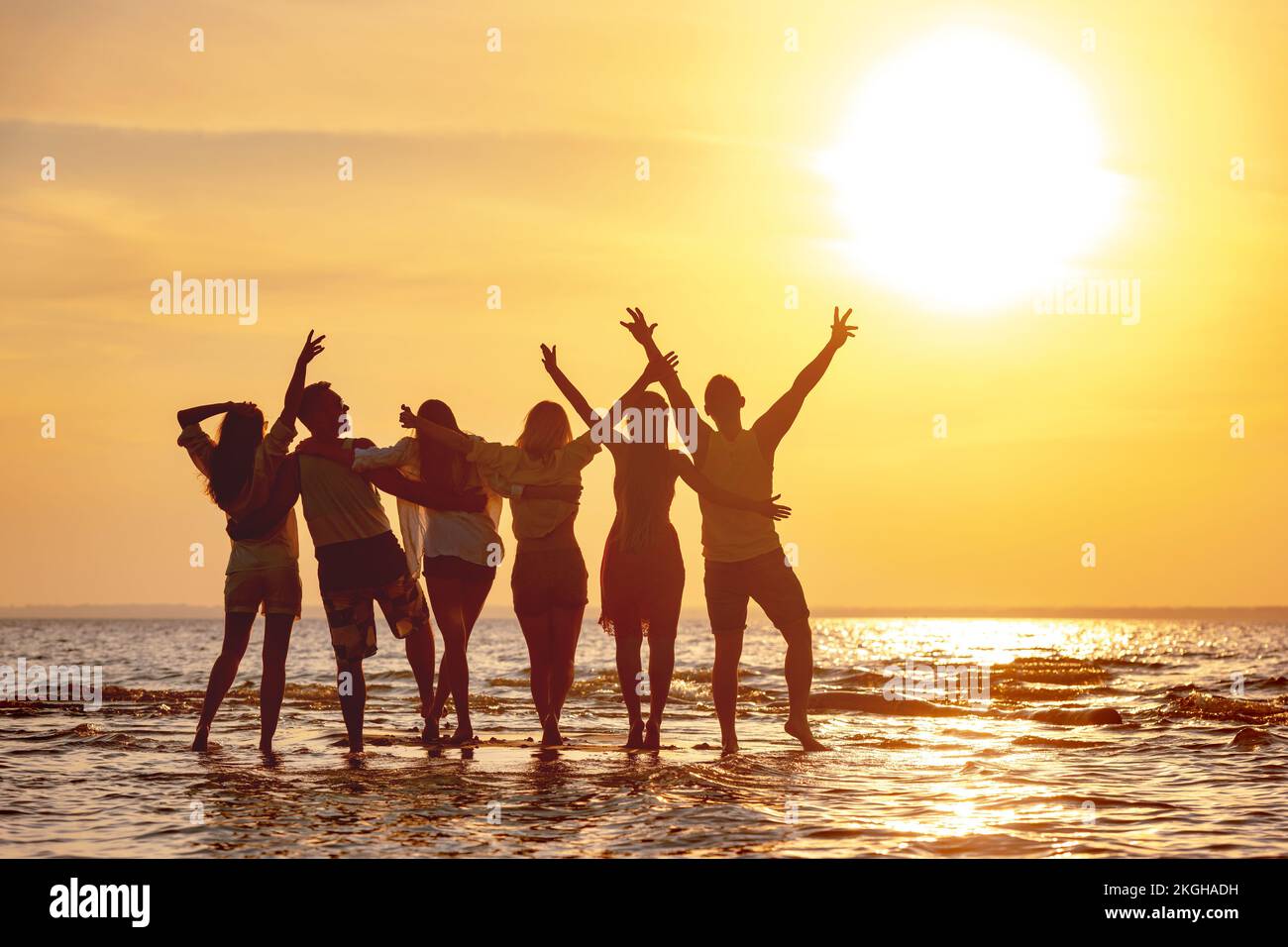Eine Gruppe glücklicher junger Freunde amüsiert sich am Sunset Beach Stockfoto