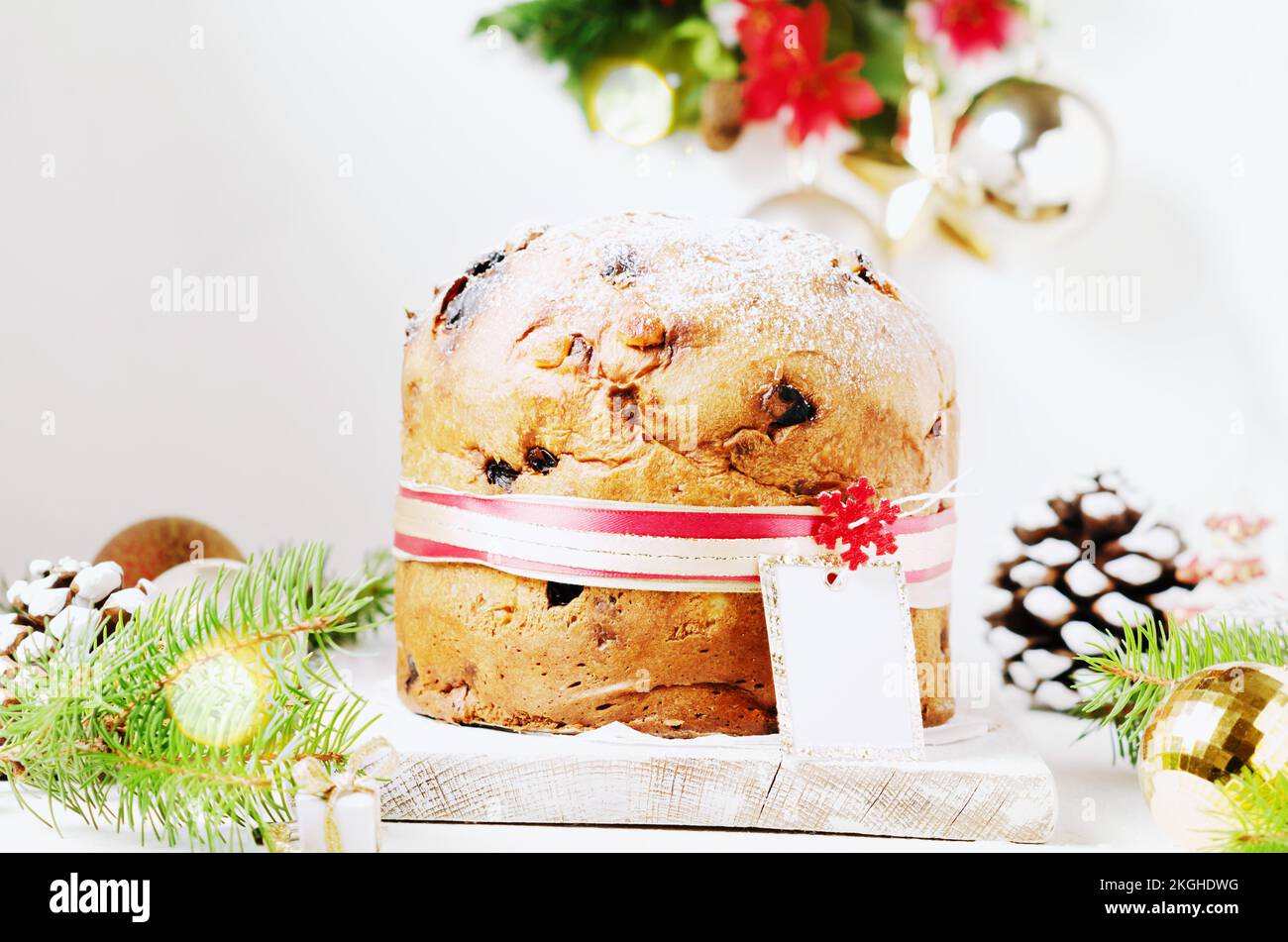 Panettone: Italienisches weihnachtliches süßes Hefebrot auf festlichem Servierteller auf einem Holztisch. Stockfoto