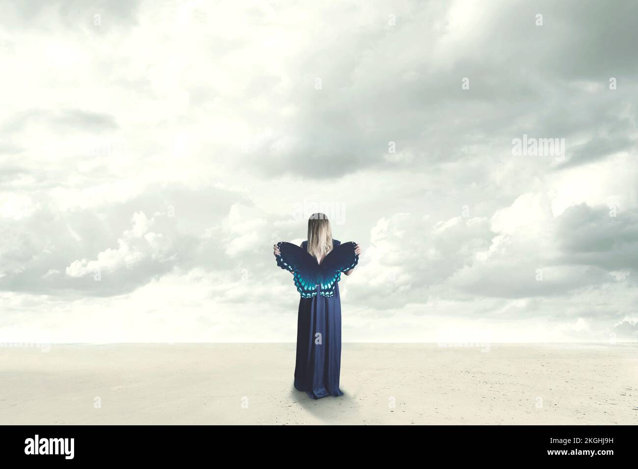 Surreale Frau hält vor sich einen bunten Schmetterling mit offenen Flügeln, Konzept der Freiheit Stockfoto