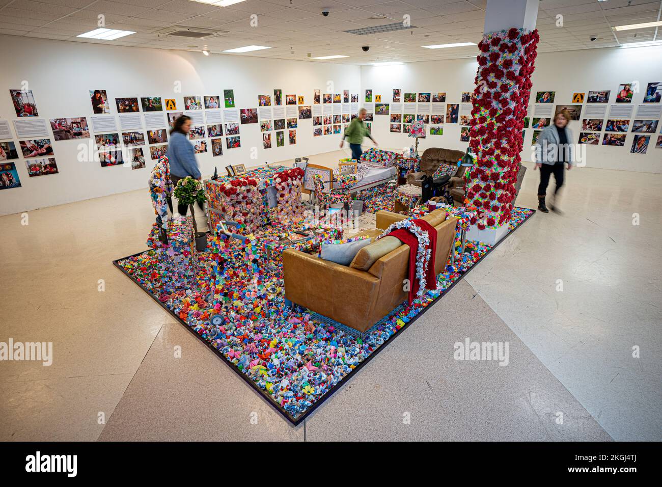 Eine Installation von Blumen, die Carina Andrews anlässlich des Carers Rights Day am 24. November im Einkaufszentrum Galleries in Broadmead, Bristol, entworfen hat. Das Stück besteht aus 40.138 Papierblumen, von denen jede eine unbezahlte Pflegekraft in der Gegend von Bristol repräsentiert. Die Blumen werden 2022 von Pflegekräften und Freiwilligen hergestellt und decken ein Modell des Wohnzimmers von Carinas Eltern ab. Bilddatum: Mittwoch, 23. November 2022. Stockfoto
