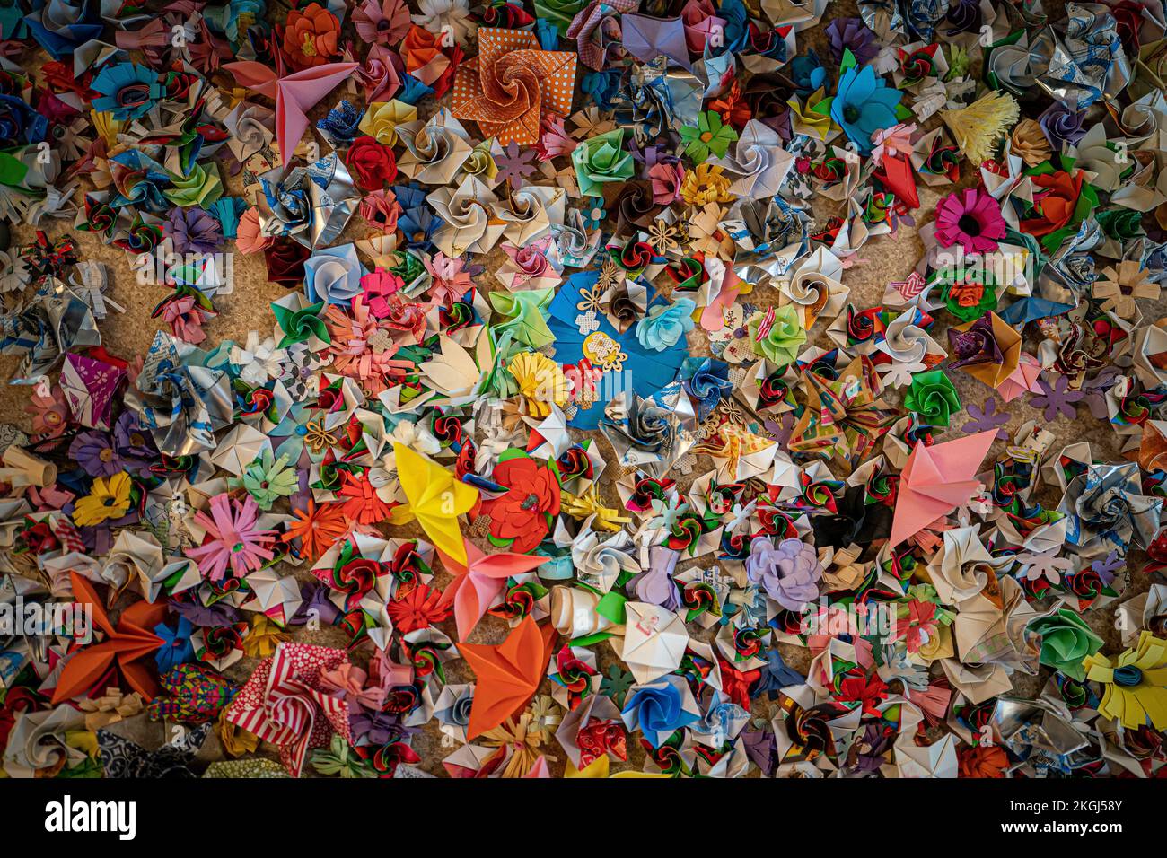 Nahaufnahme einer Blume aus Papier, die Teil einer Blumeninstallation ist, die von Carina Andrews anlässlich des Carers Rights Day am 24. November im Galleries Shopping Centre in Broadmead, Bristol, entworfen wurde. Das Stück besteht aus 40.138 Papierblumen, von denen jede eine unbezahlte Pflegekraft in der Gegend von Bristol repräsentiert. Die Blumen werden 2022 von Pflegekräften und Freiwilligen hergestellt und decken ein Modell des Wohnzimmers von Carinas Eltern ab. Bilddatum: Mittwoch, 23. November 2022. Stockfoto