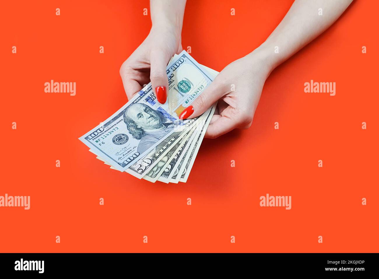 Dollarscheine in weiblichen Händen mit roter Maniküre Stockfoto