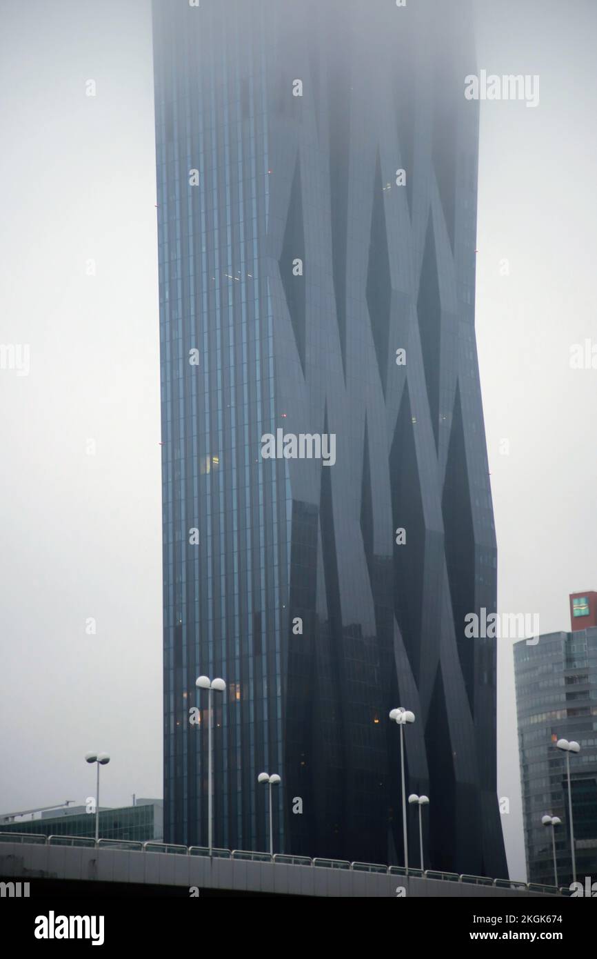 Hohes Gebäude hinter einer Brücke in Wien, Österreich. Bedeckt mit Nebel. Stockfoto