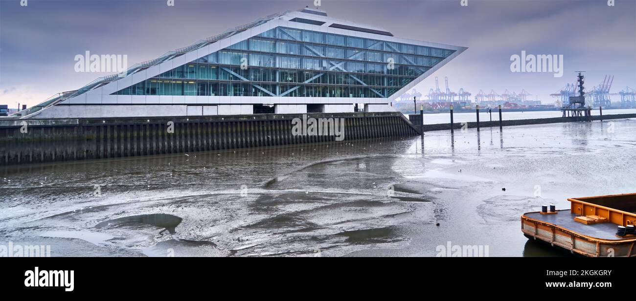 Hamburg, Deutschland, 11. November 2022: Das Dockland, ein futuristisches Bürogebäude im Hamburger Hafen, bei düsterem Wetter und fließendem Wasser auf dem Ri Stockfoto