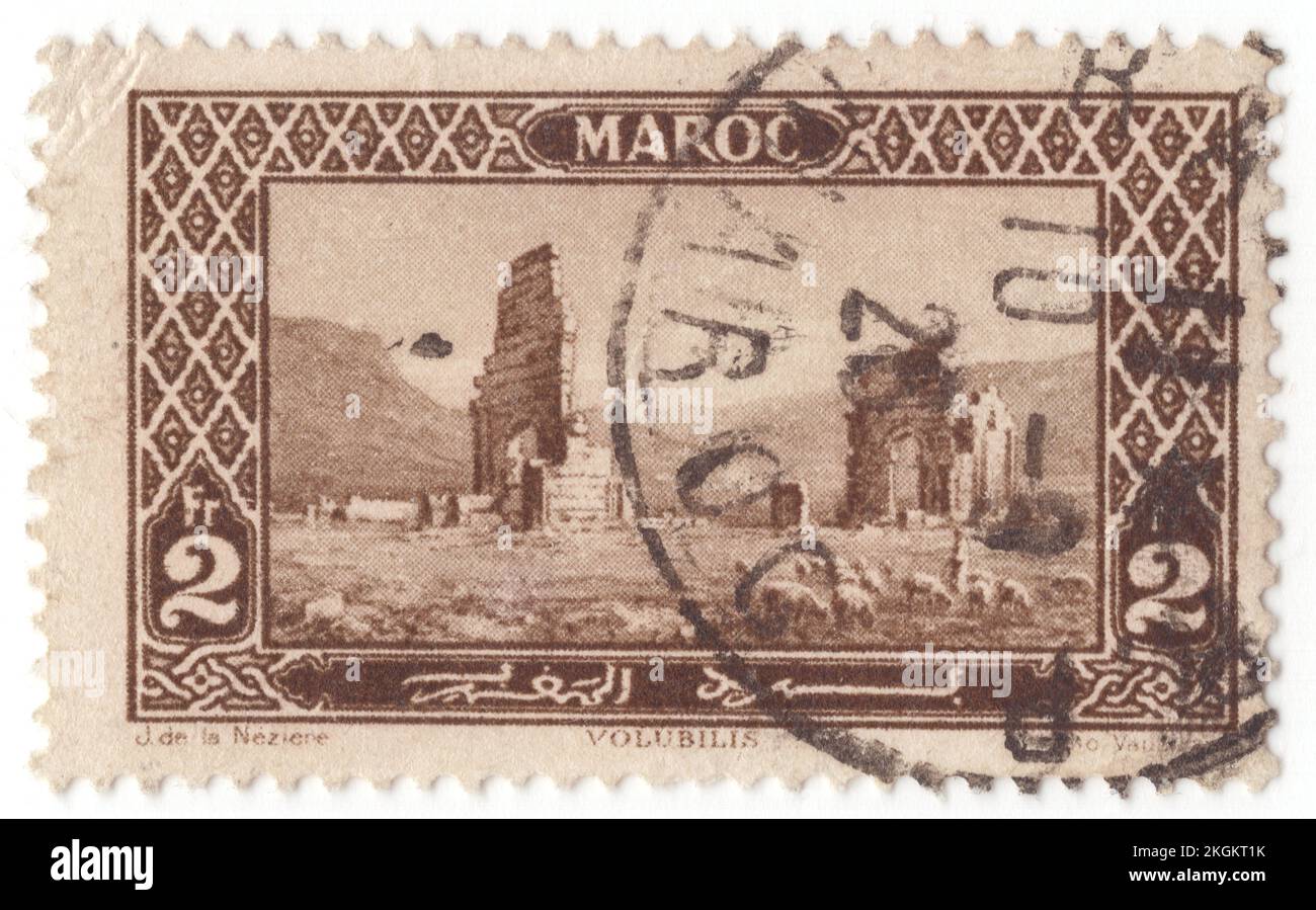 FRANZÖSISCH-MAROKKO - 1917: Eine schwarz-braune Briefmarke von 2 Francs mit römischen Ruinen, Volubilis, ist eine teilweise ausgegrabene Berber-römische Stadt in Marokko in der Nähe der Stadt Meknes und könnte die Hauptstadt des Königreichs Mauretanien gewesen sein, zumindest seit der Zeit von König Juba II Vor Volubilis war die Hauptstadt des Königreichs vielleicht in Gilda. Erbaut in einem fruchtbaren landwirtschaftlichen Gebiet, entwickelte sie sich ab dem 3.. Jahrhundert v. Chr. als Berber, dann als proto-karthaginische Siedlung, bevor sie die Hauptstadt des Königreichs Mauretanien war Stockfoto