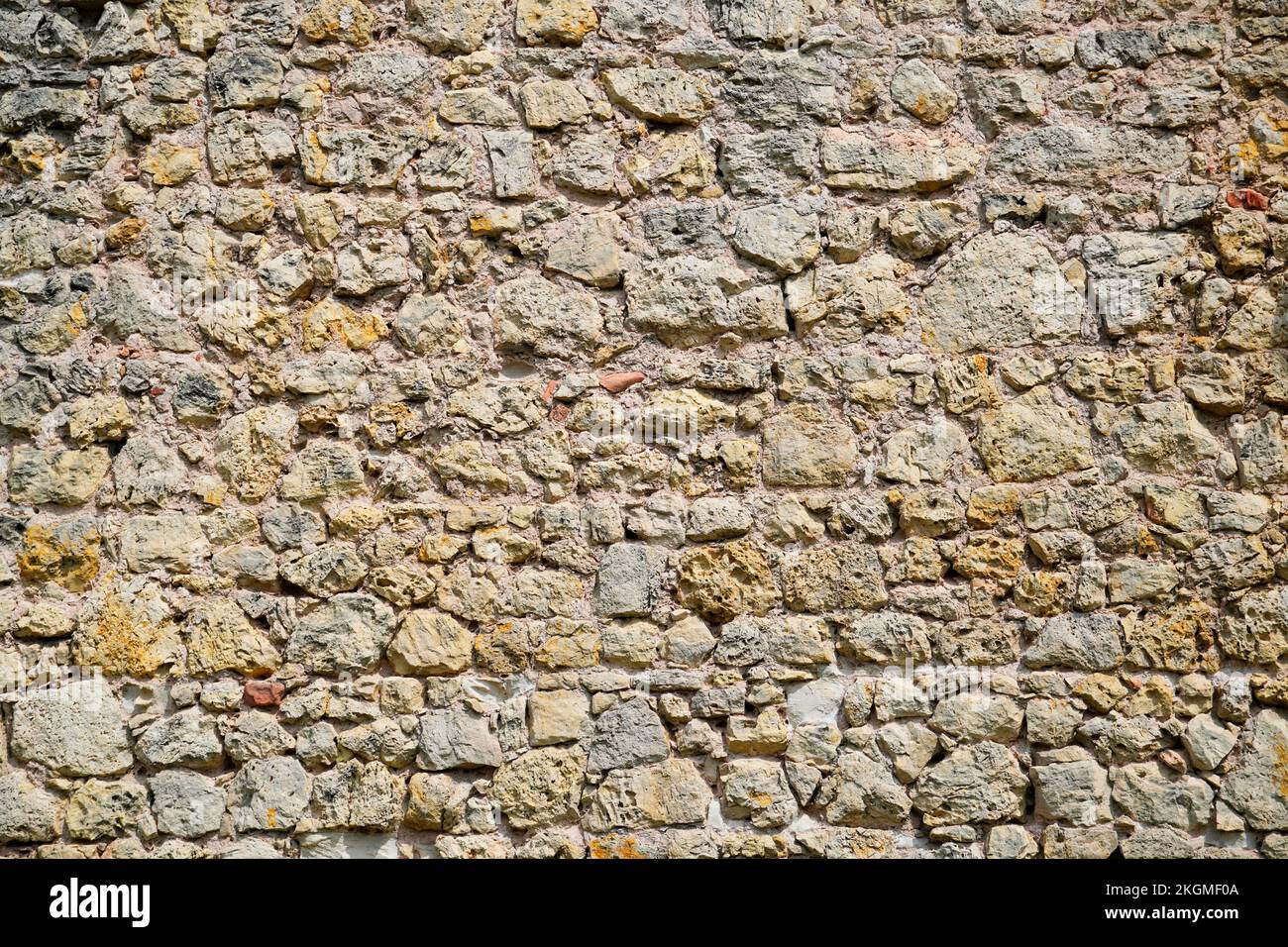 Braune, rustikale Steinmauer eines alten Schlosses. Steinhintergrund. Stockfoto