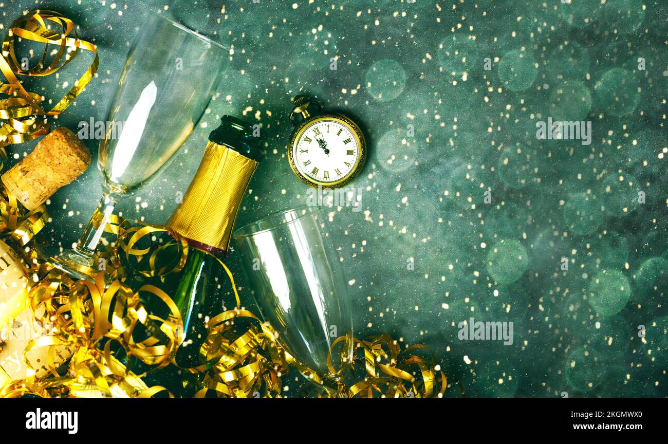 Frohes neues Jahr. Draufsicht auf Champagnerflasche, zwei Gläser, goldene Luftschlangen, antike Uhr und weihnachtsbeleuchtung mit Platz für Text über Grunge Backgroun Stockfoto