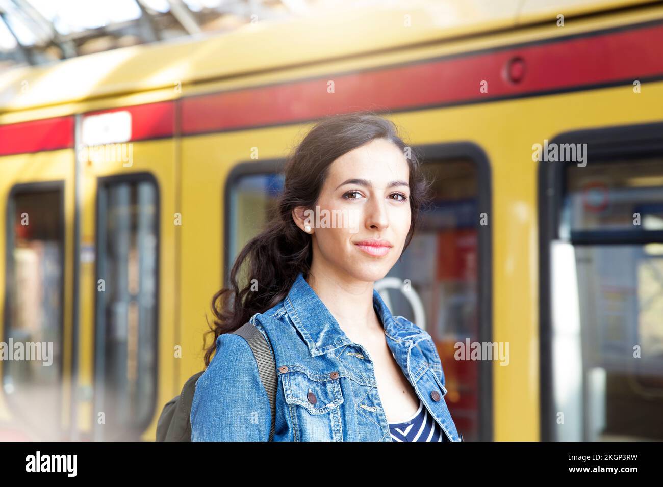 Deutschland, Berlin, Porträt einer jungen Frau vor dem Zug Stockfoto