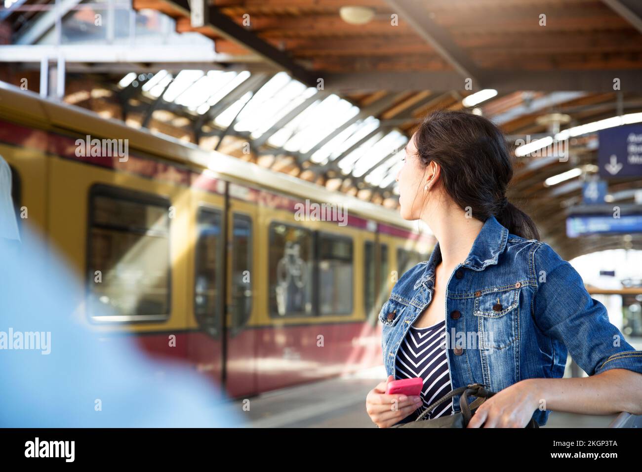 Deutschland, Berlin, junge Frau, die den Zug beobachtet Stockfoto