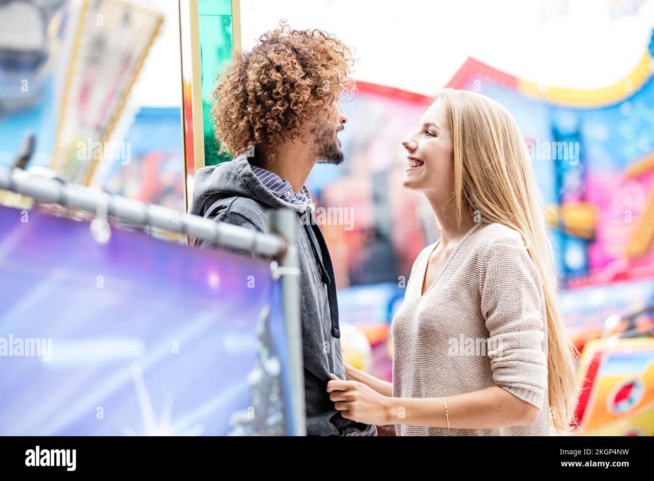 Ein glückliches Paar auf einem Karussell auf einem Jahrmarkt Stockfoto