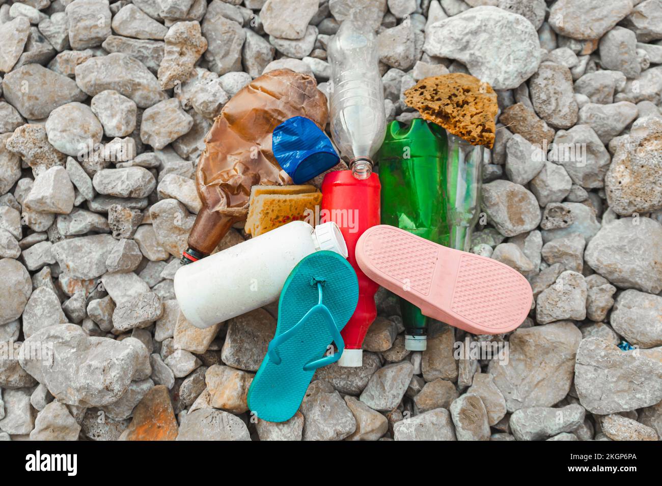 Plastikmüllhaufen auf Steinen am Strand Stockfoto