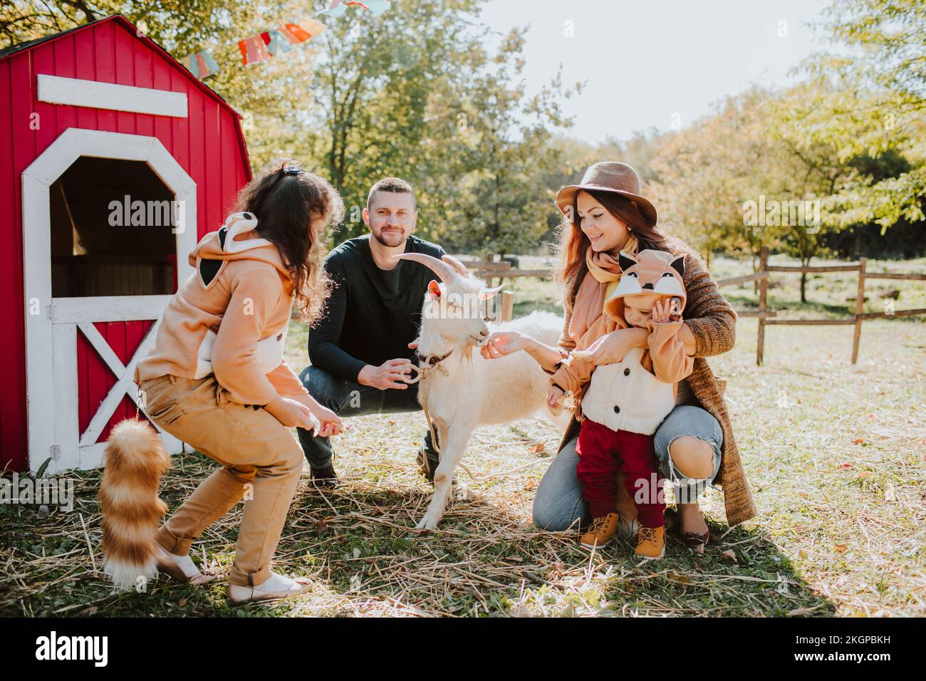 Lächelnde Eltern mit Kindern, die auf dem Bauernhof Fuchskostüme tragen Stockfoto