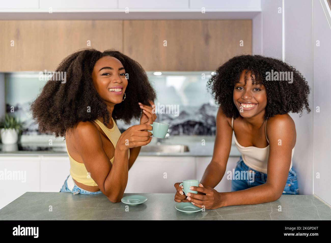 Glückliche multirassische Freunde, die Kaffee in der Küche trinken Stockfoto