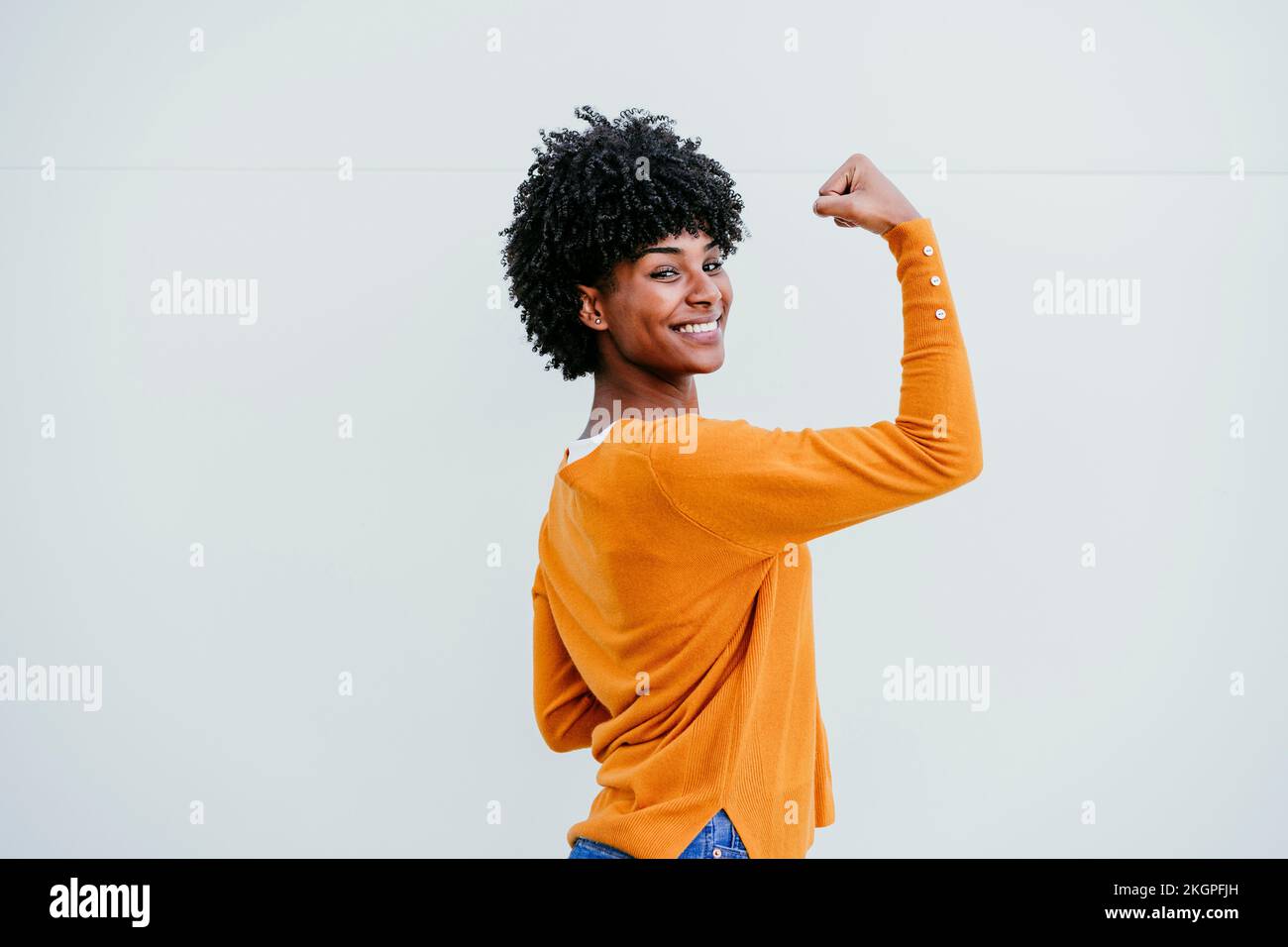 Lächelnde Frau mit schwarzem Haar und Muskeln Stockfoto