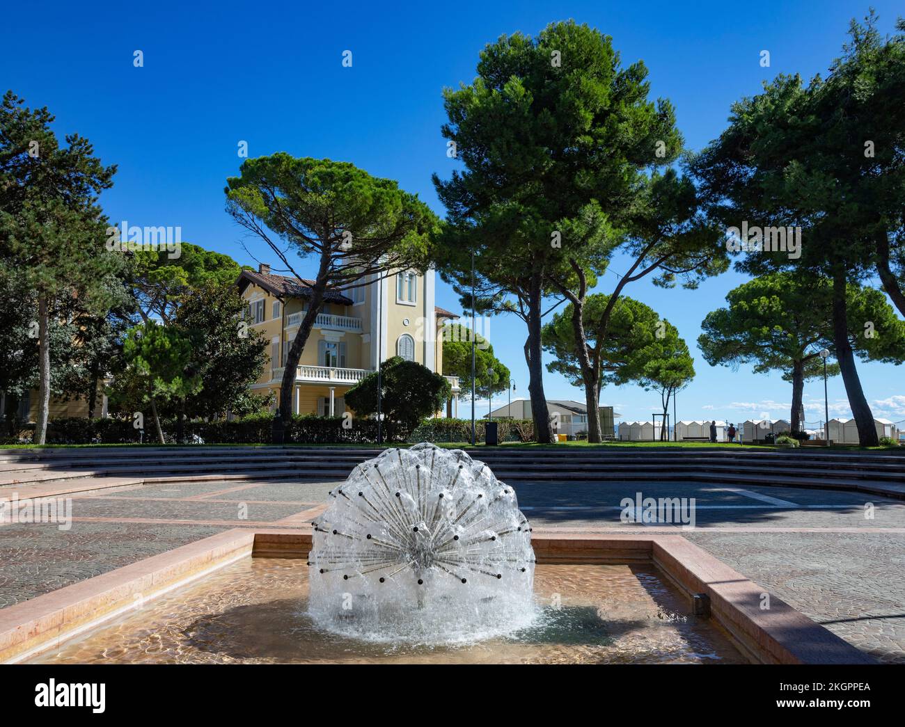 Italien, Friaul-Julisch Venetien, Grado, Stadtplatz mit modernem Brunnen im Sommer Stockfoto