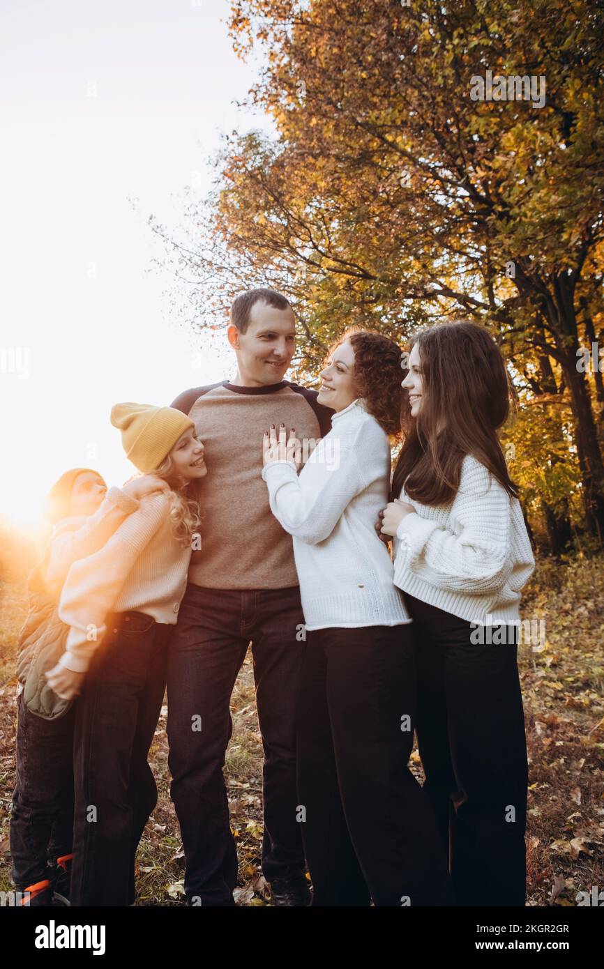 Glücklicher Mann mit Familie, der an einem sonnigen Tag im Wald steht Stockfoto