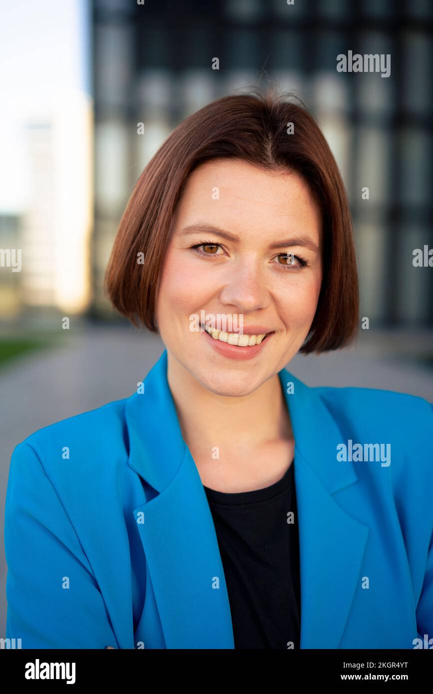 Glückliche Geschäftsfrau mit kurzen Haaren und blauem Blazer Stockfoto