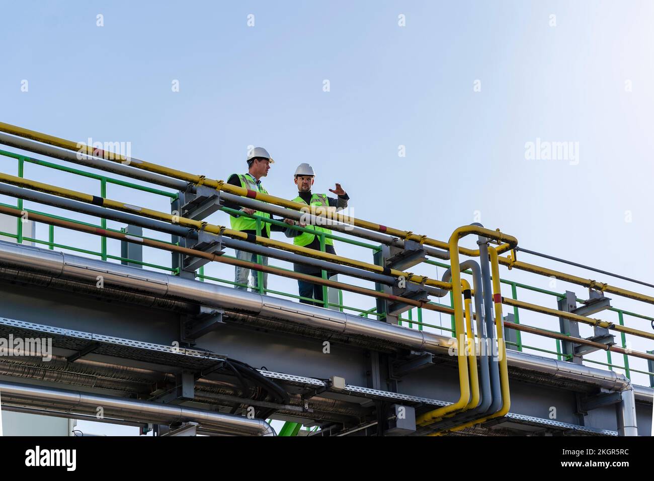 Ingenieure, die an sonnigen Tagen in der Recyclinganlage arbeiten Stockfoto