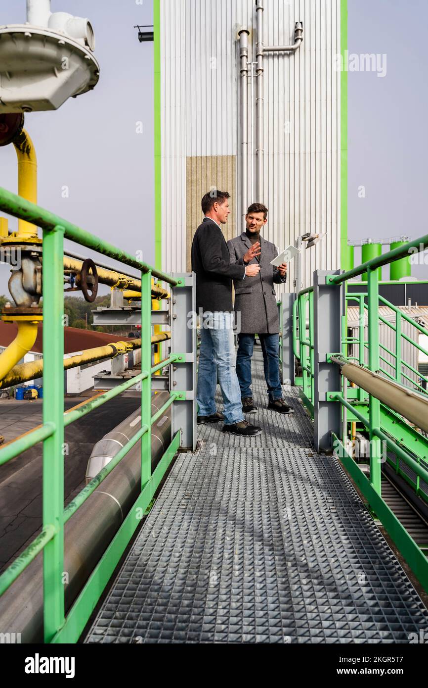 Geschäftsleute diskutieren in der Recyclinganlage Stockfoto