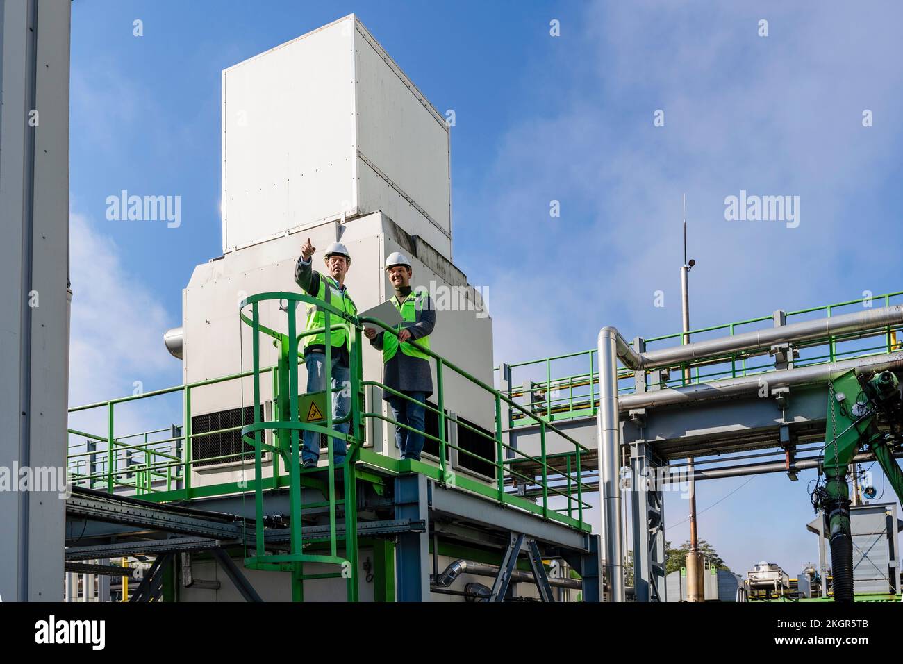 Geste und Besprechung mit Kollegen in der Recyclinganlage Stockfoto