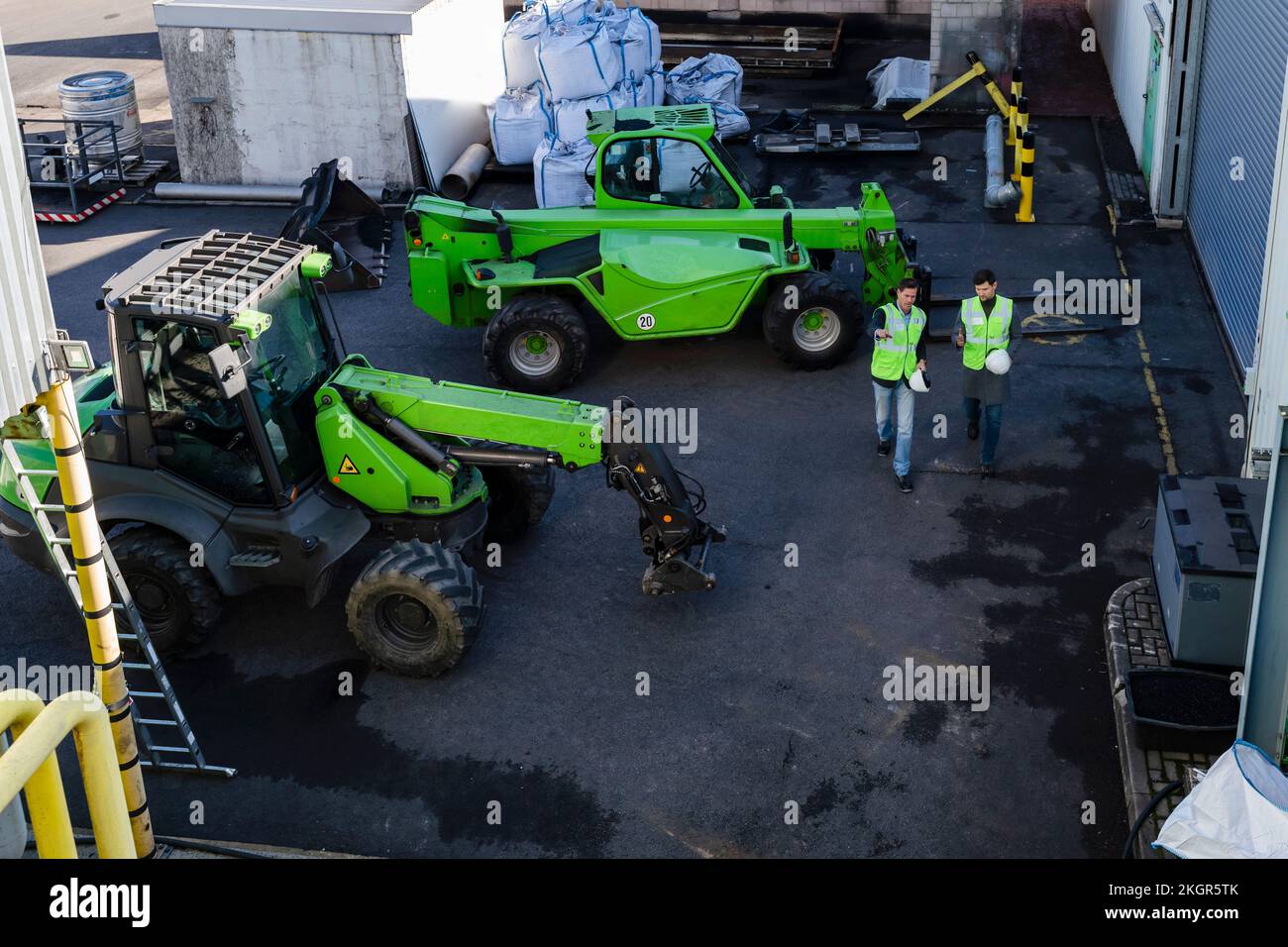 Ingenieure, die von Industriemaschinen in der Recyclinganlage diskutieren Stockfoto